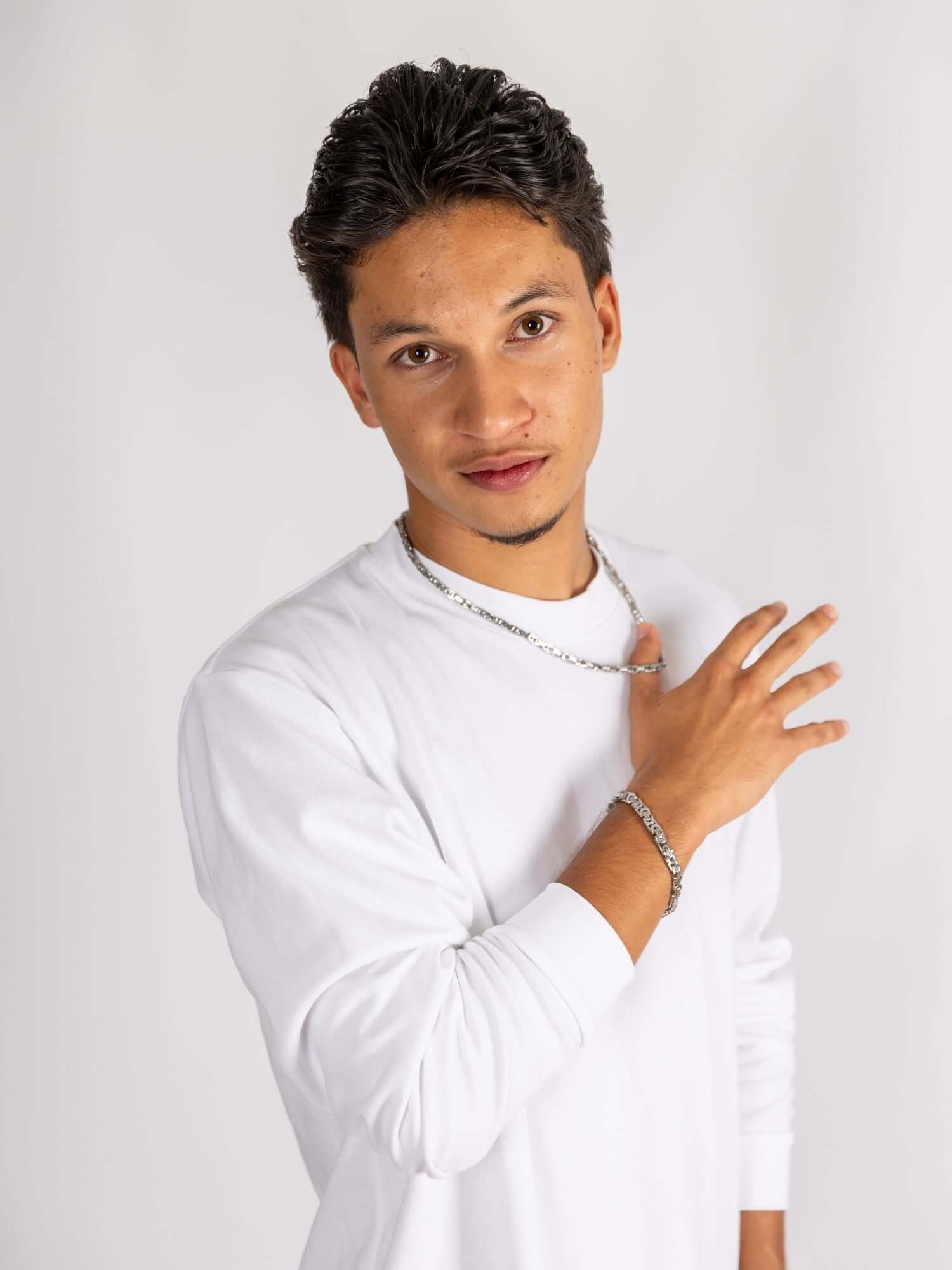 Konings schakel ketting en armband gedragen door man met een wit shirt