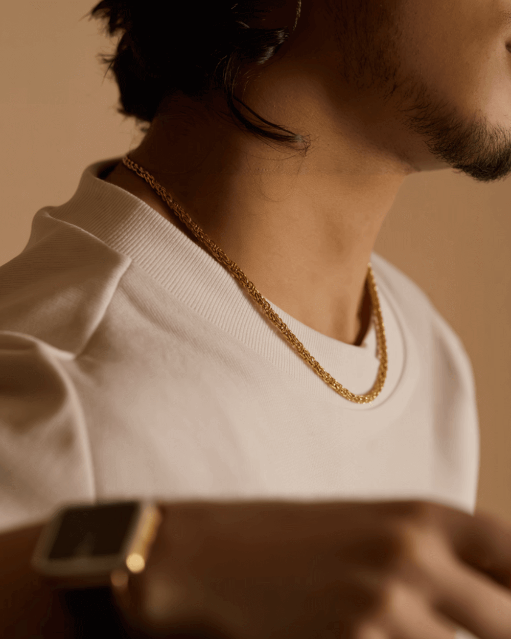 Man met een gouden ketting als onderdeel van populaire producten in sieraden.