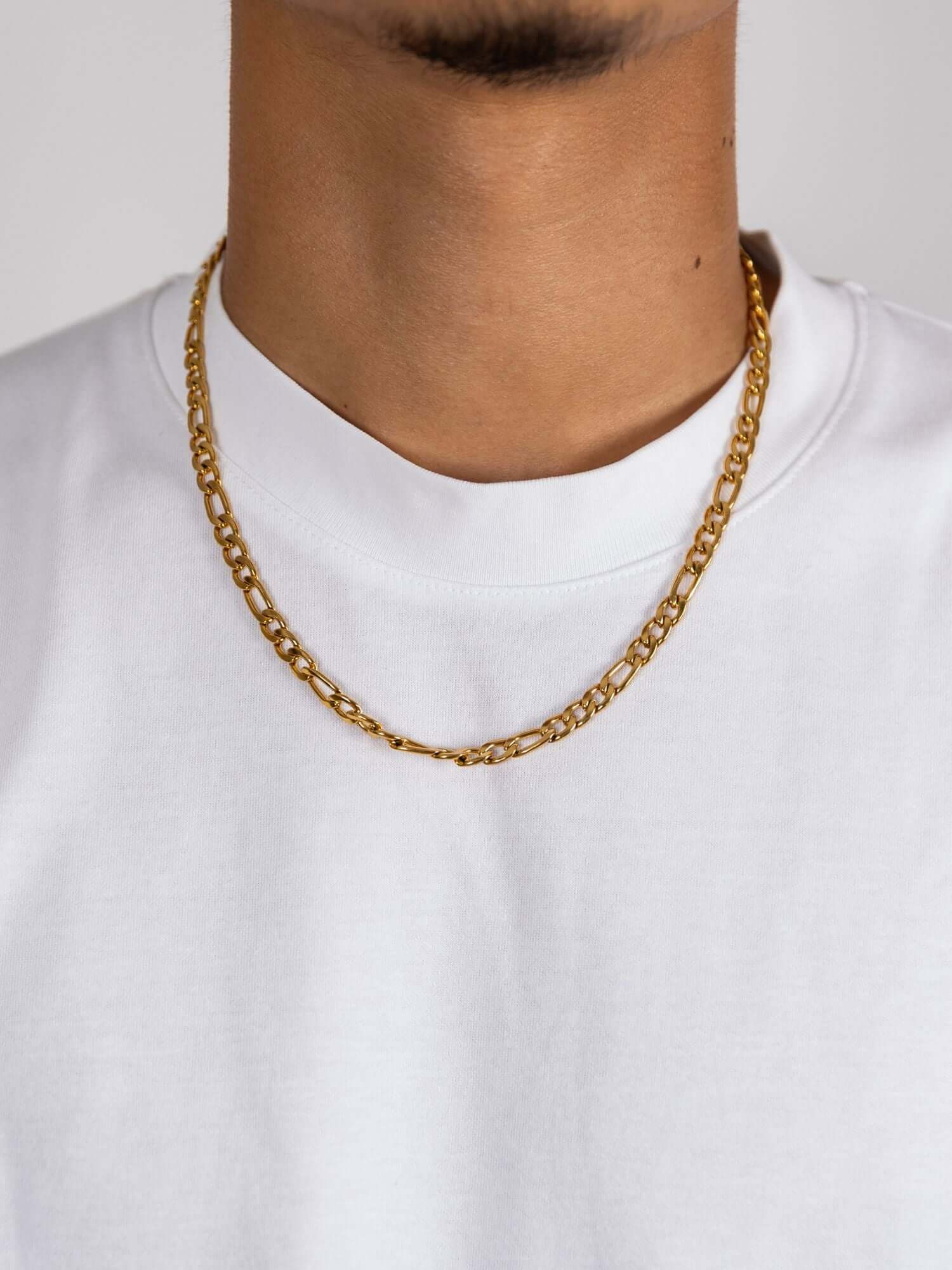 Gouden figaro ketting 3MM en 6MM gedragen door een model in een wit T-shirt.