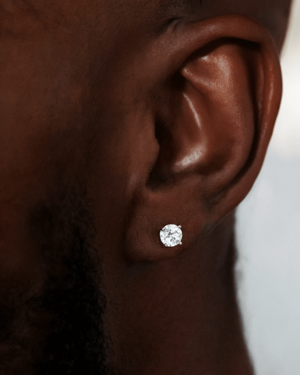 Diamanten Oorbellen Moissanite 5MM in witgouden zetting, gepresenteerd op een oor.