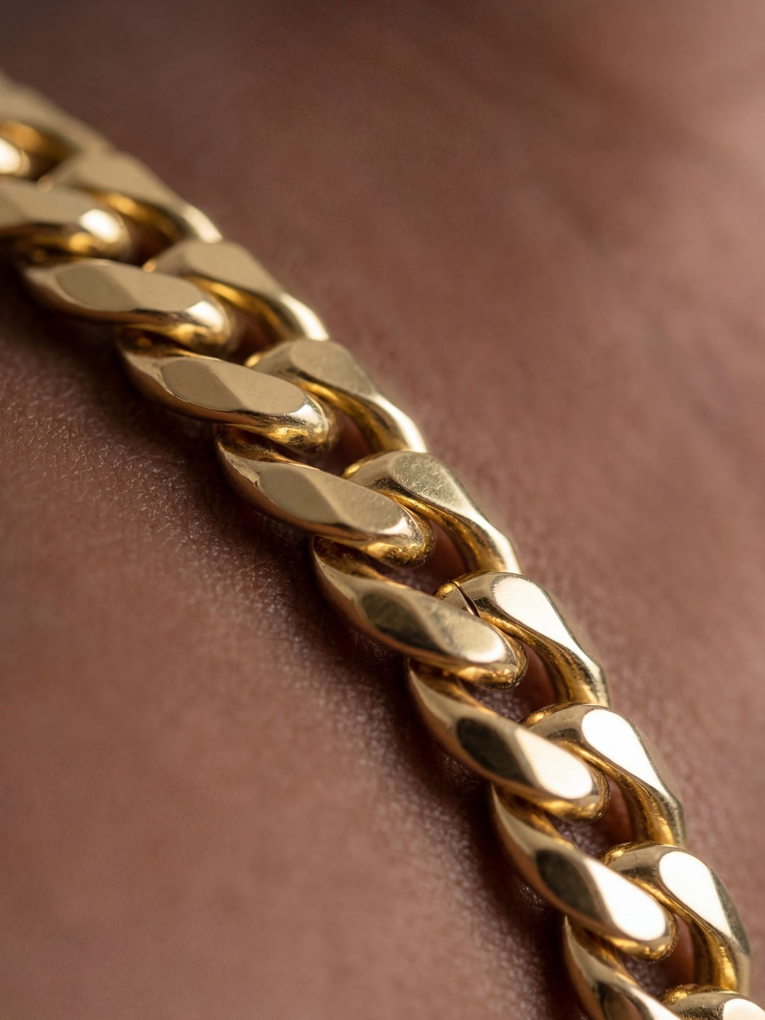 Cuban Armband 18K Goud Verguld (5mm) close-up van 5mm Cuban schakel armband met glanzende 18K goudlaag op pols