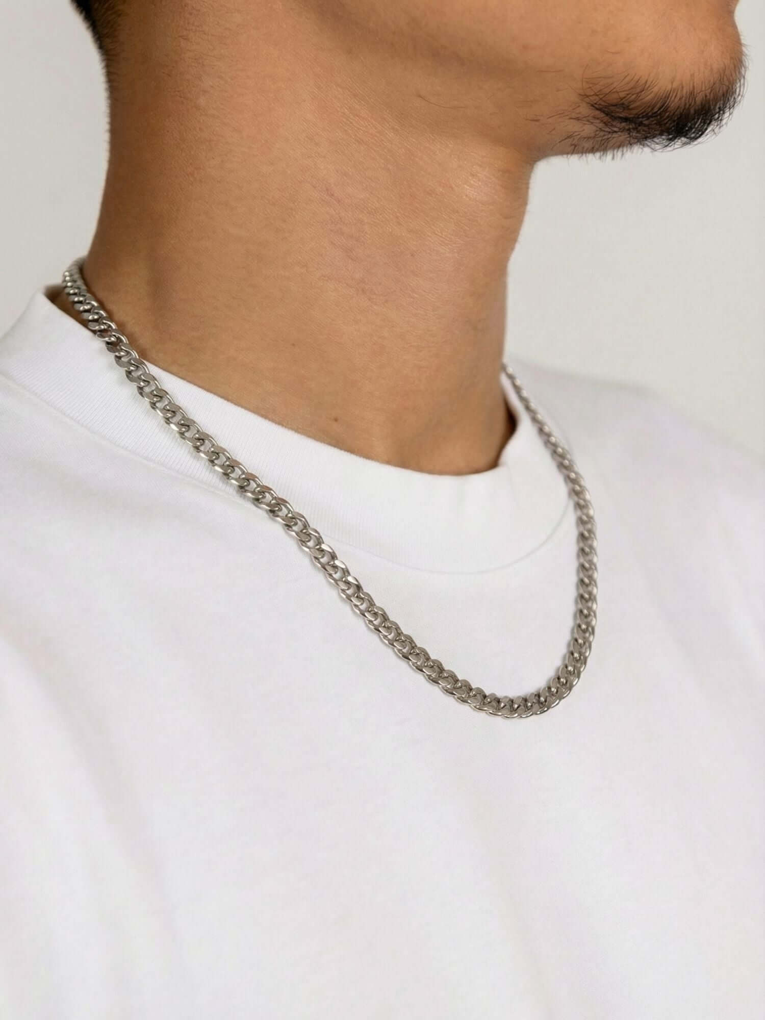 Cuban Chain Silver Stainless Steel (3mm, 5mm & 7mm) worn around the neck, silver-tone stainless steel Cuban link chain with lobster clasp