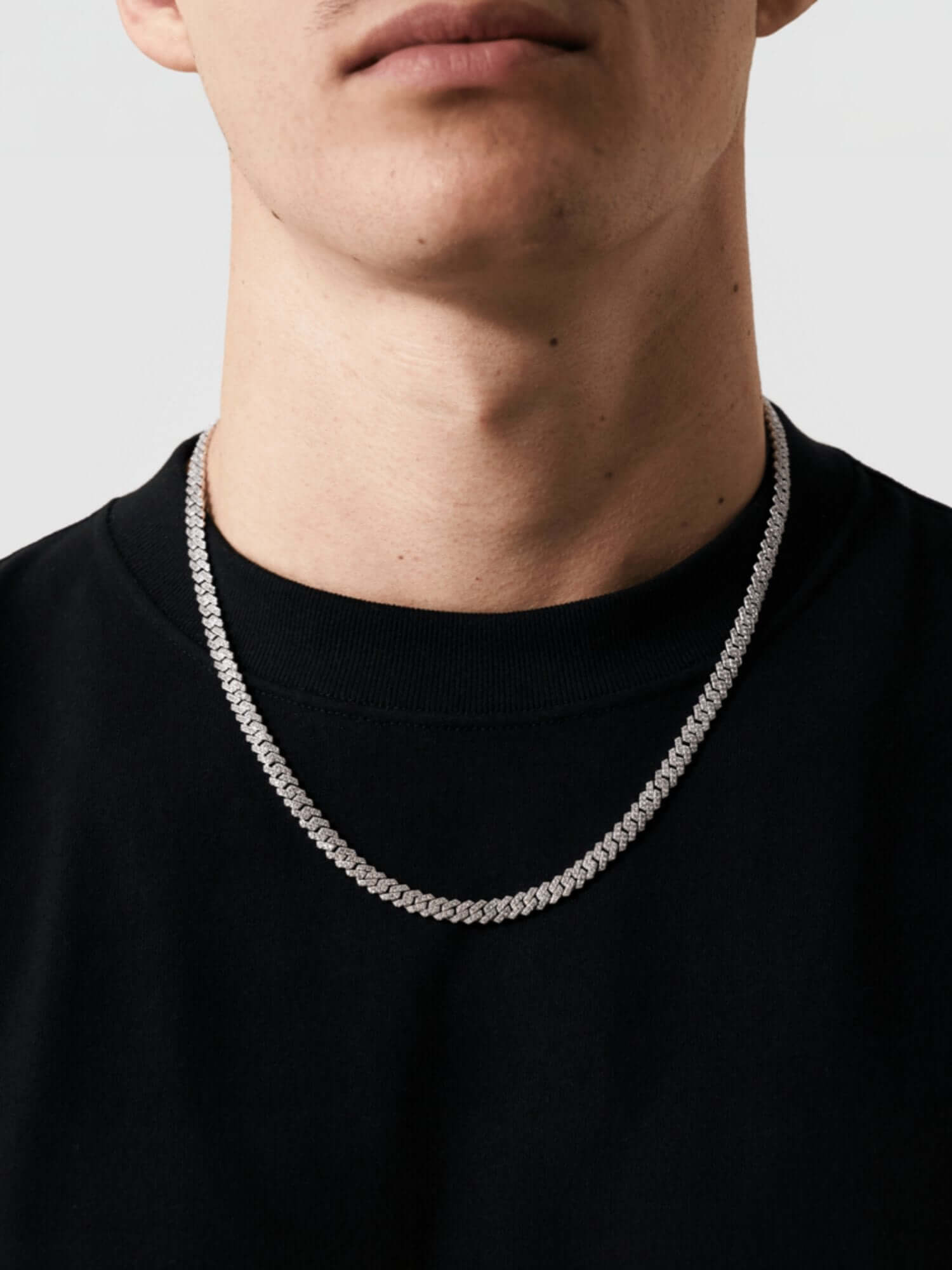 Cuban link ketting zilver ICED OUT 6MM op zwart T-shirt, perfect voor luxe en stijl.