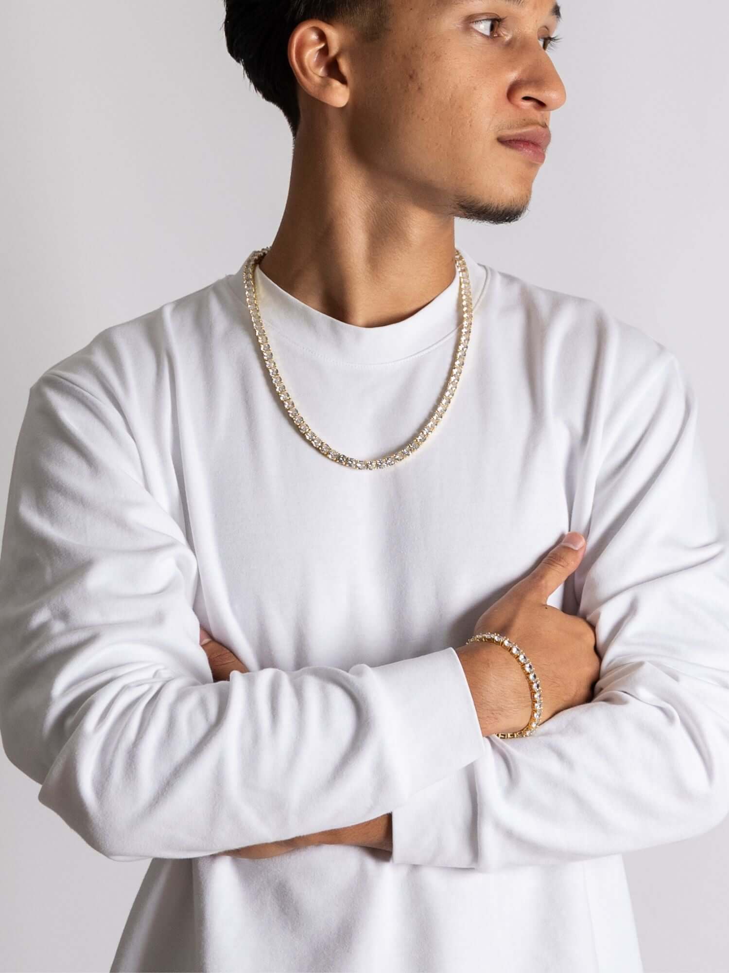 Man wearing a gouden tennis ketting in a casual outfit, showcasing its elegant design and shine.