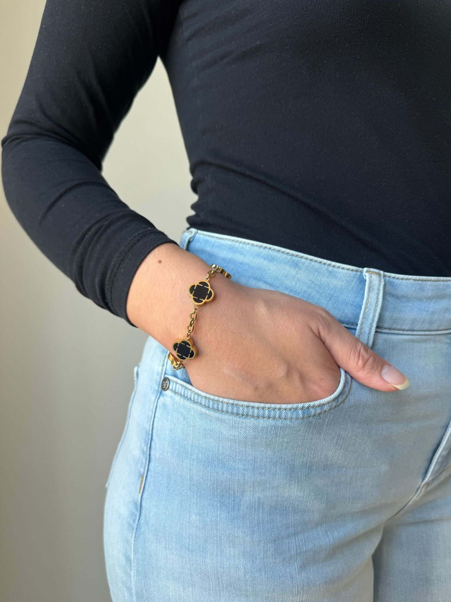 Bracciale trifoglio d'oro con onice nero, indossato al polso
