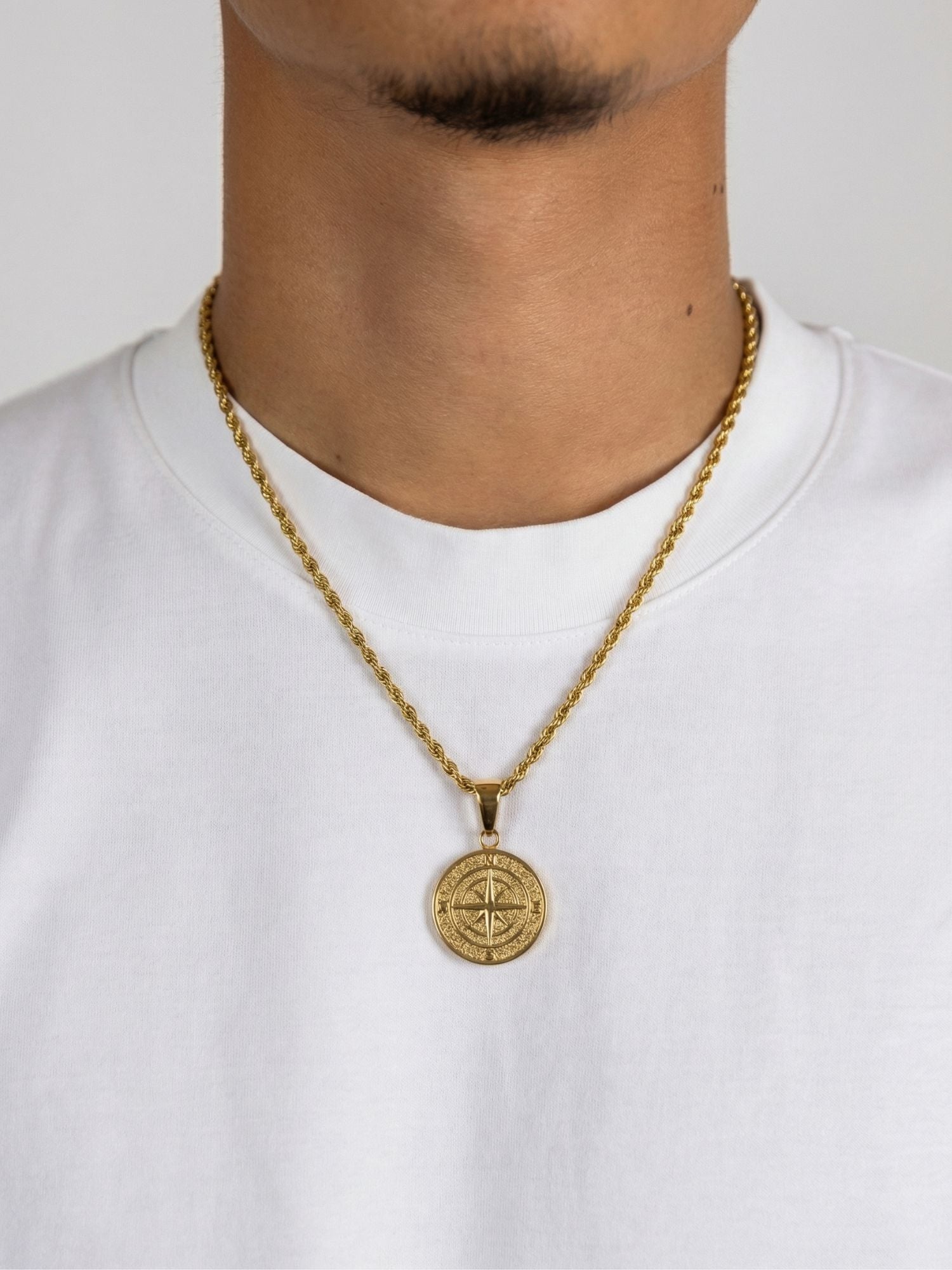 Kompas Hanger Goud, gouden kompas pendant worn on a chain, symbolizing ambition and direction.