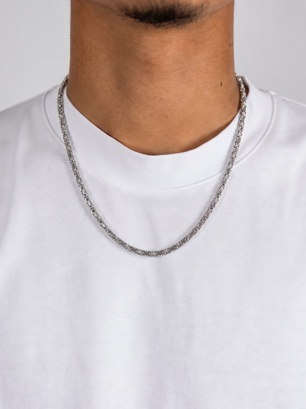 Collana maglia king acciaio (4 mm) indossata da un modello con T-shirt bianca, vista frontale