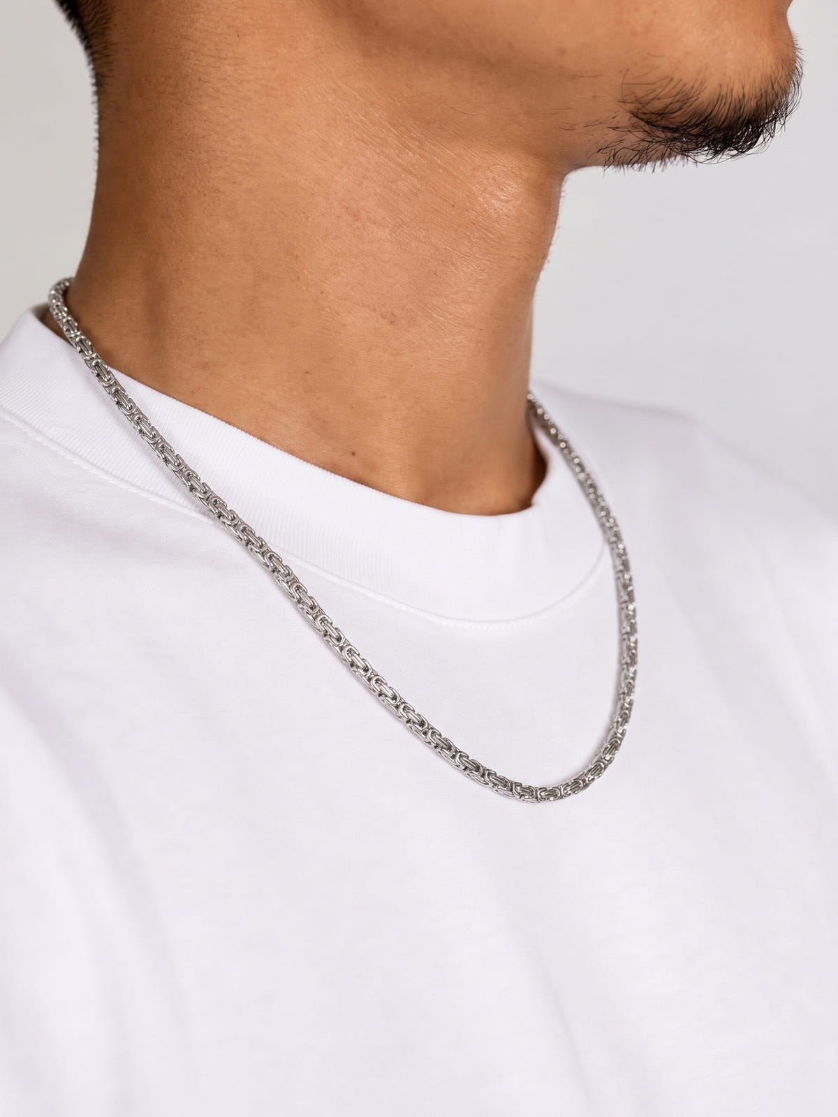 Collana maglia king acciaio (4 mm) indossata da un modello con T-shirt bianca, vista laterale
