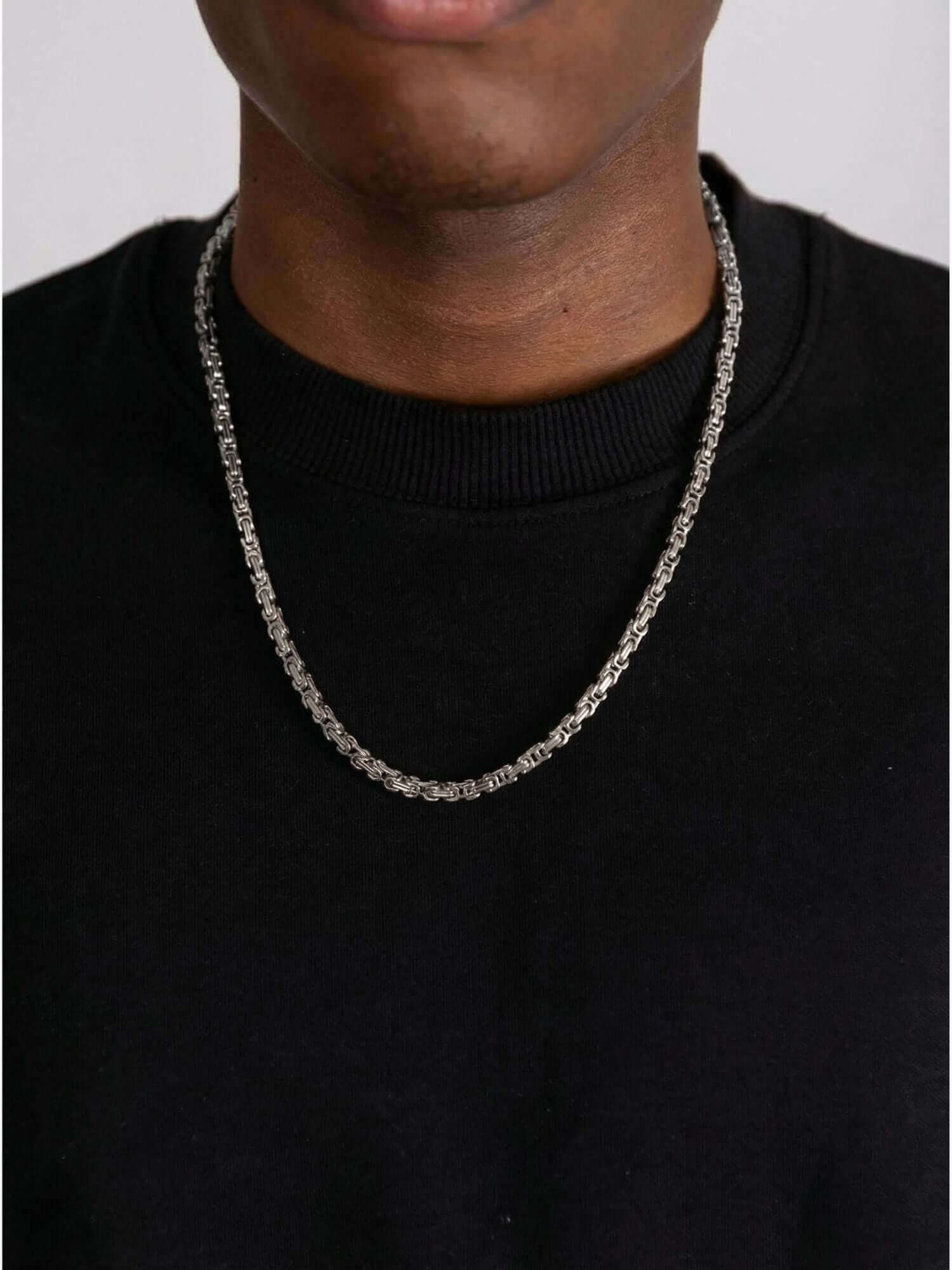 Silver stainless steel king chain (5mm) worn around the neck, with a polished finish
