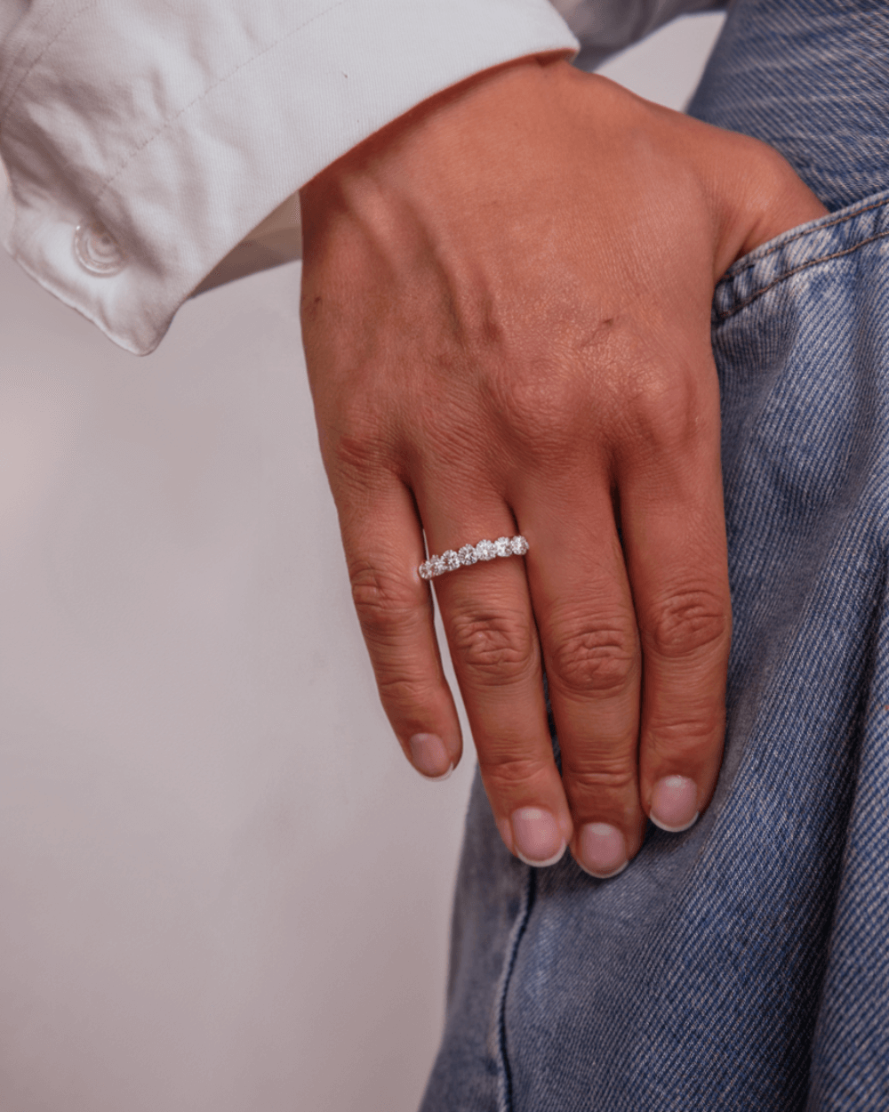 Moissanite tennis ring in 925 sterling silver and sparkling diamonds worn by a woman.