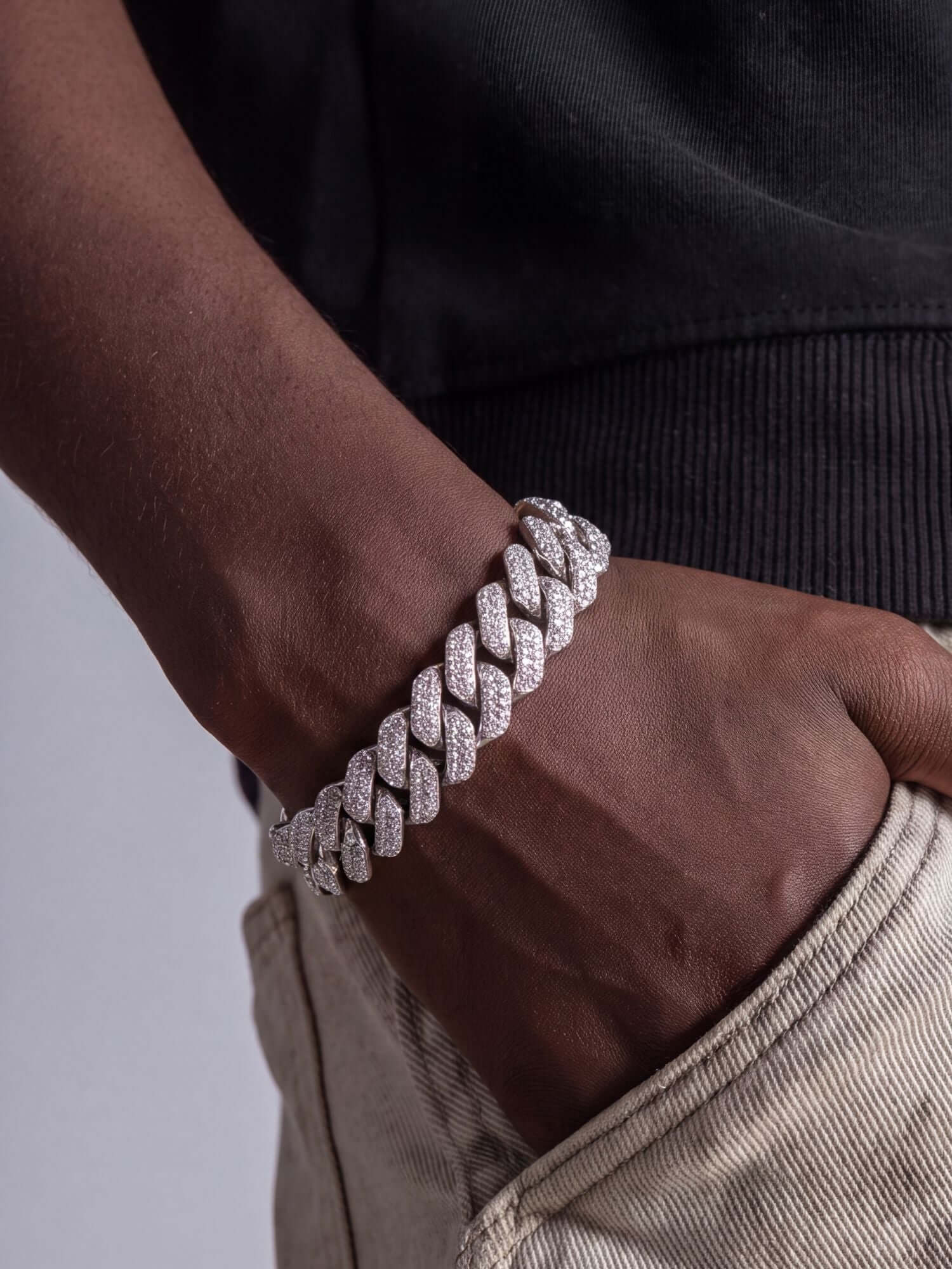 Moissanite Cuban Link Armband 925 Zilver ICED OUT (12MM) met fonkelende stenen, gedragen op hand.