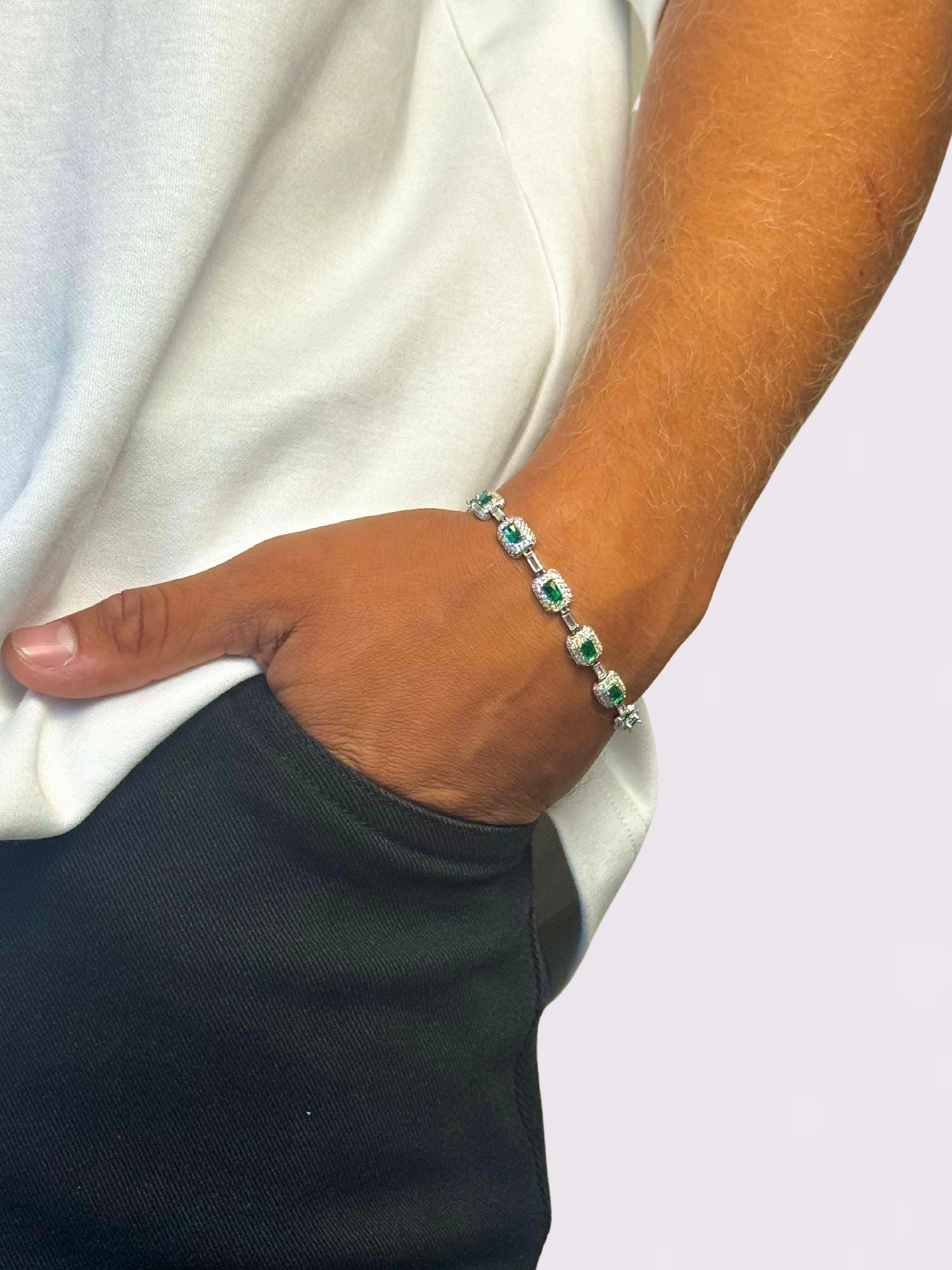 Emerald armband ICED OUT 7MM die gedragen wordt door een persoon met een witte shirt en zwarte broek.