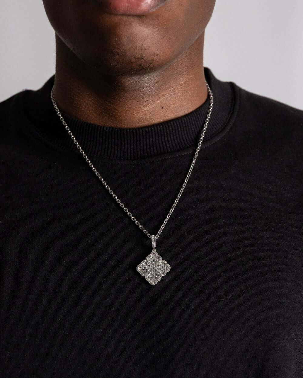 Model wearing a Clover hanger zilver necklace, showcasing its sparkling design against a black shirt.