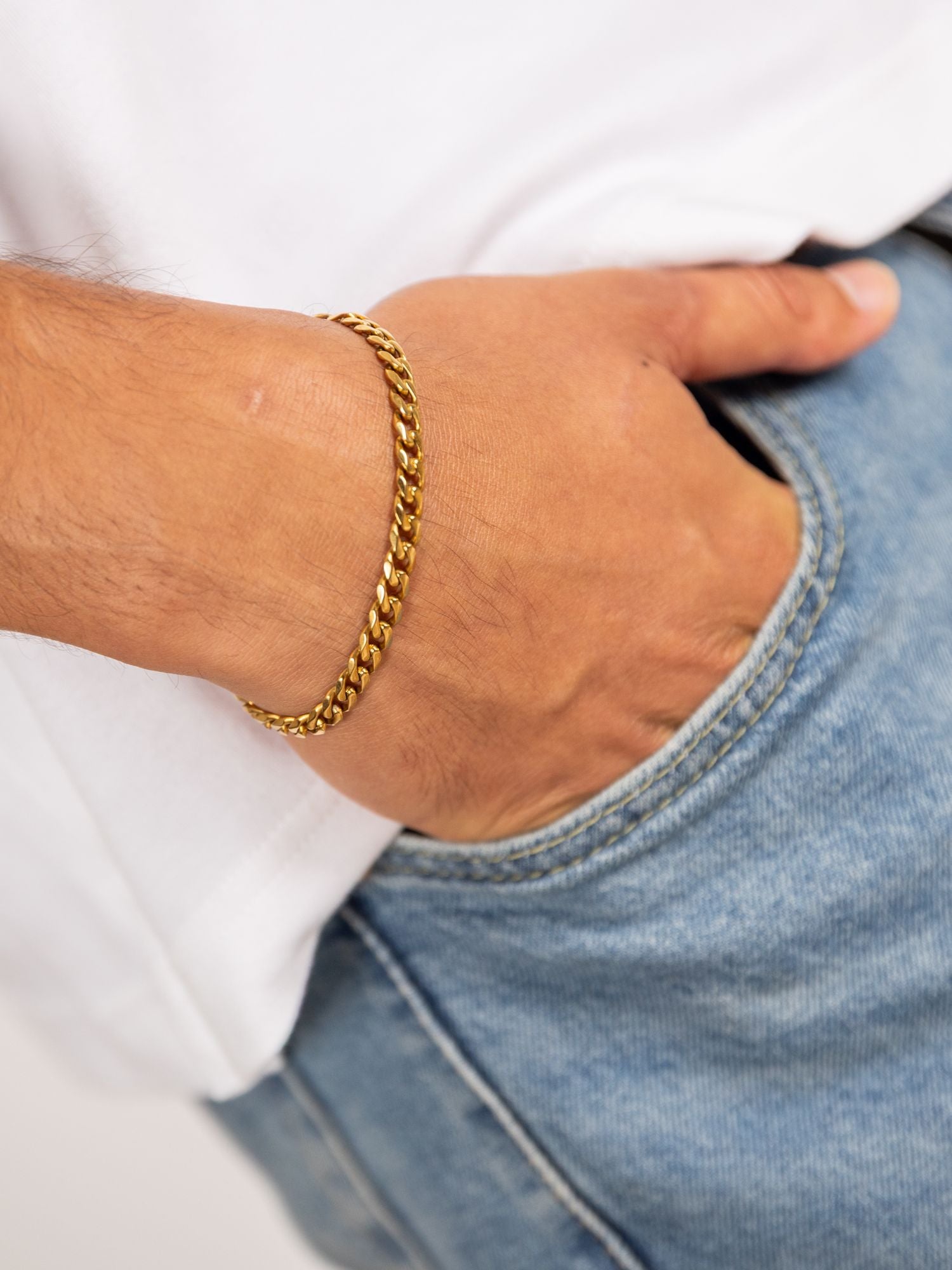 Gouden luxe cuban armband van Carpe Ice, 3MM-7MM, gedragen om een hand met een casual outfit.