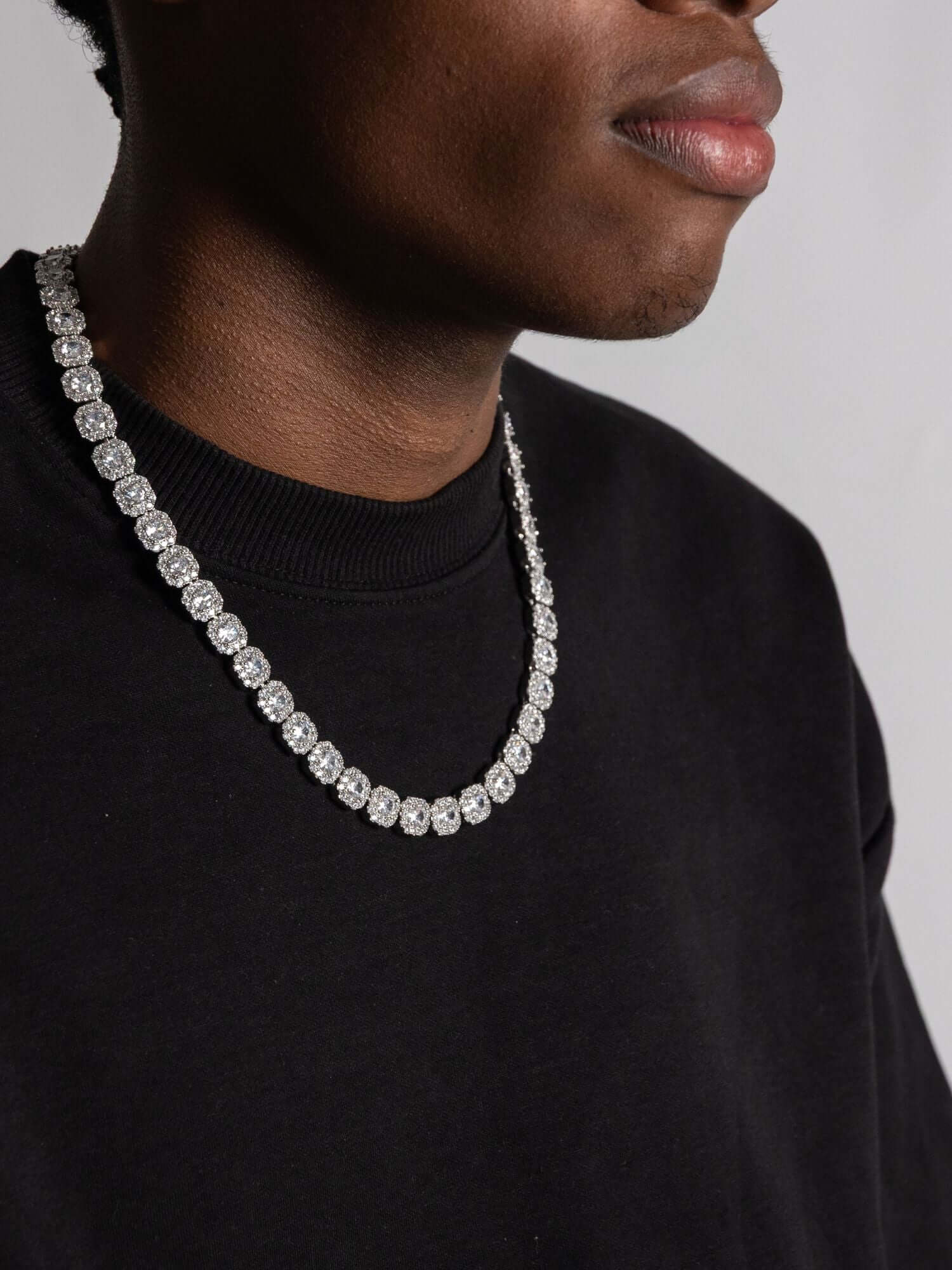 Man wearing a clustered zilveren tennis ketting, showcasing its unique design and robust texture.