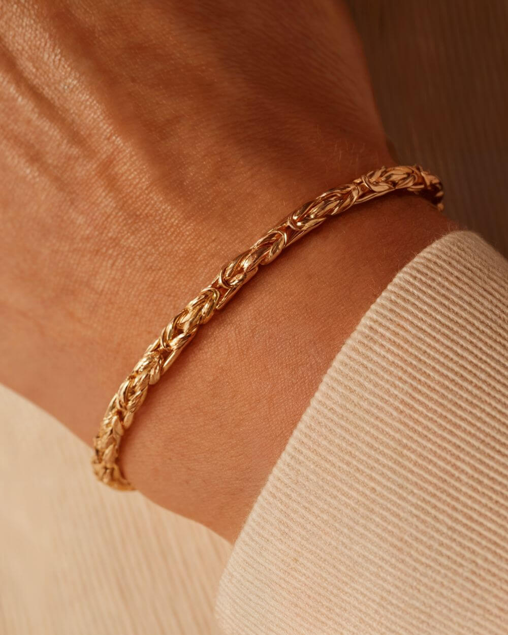 gouden koningsarmband met een hand van een persoon die deze collectie draagt