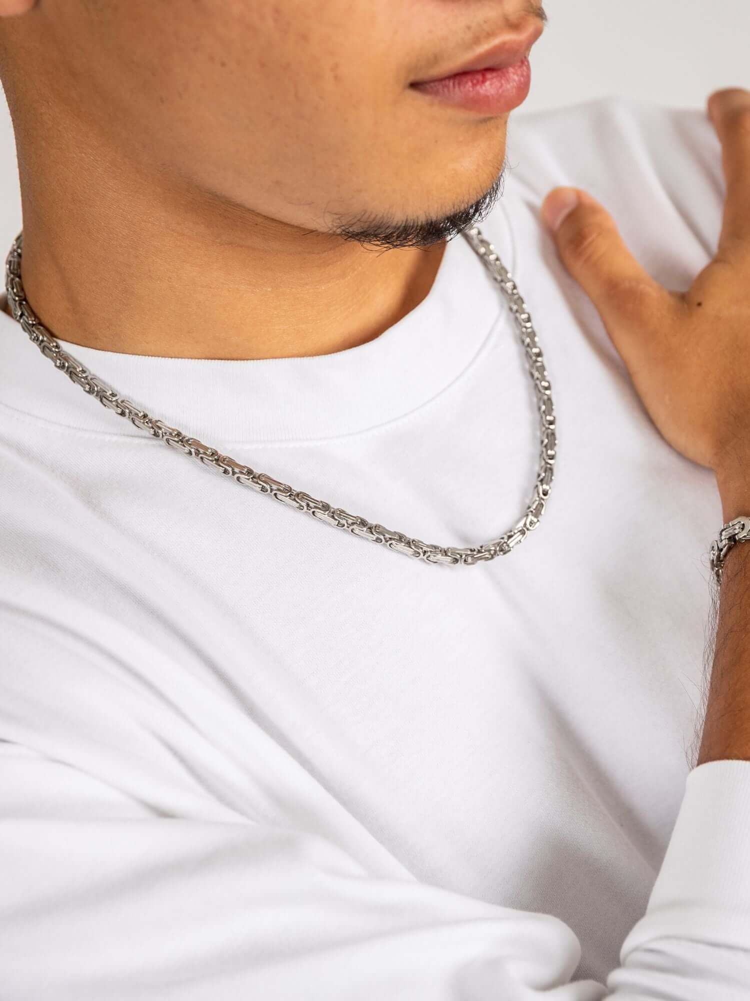 Zilveren konings schakel ketting 5MM gedragen door man in witte shirt, elegante en stoere uitstraling.