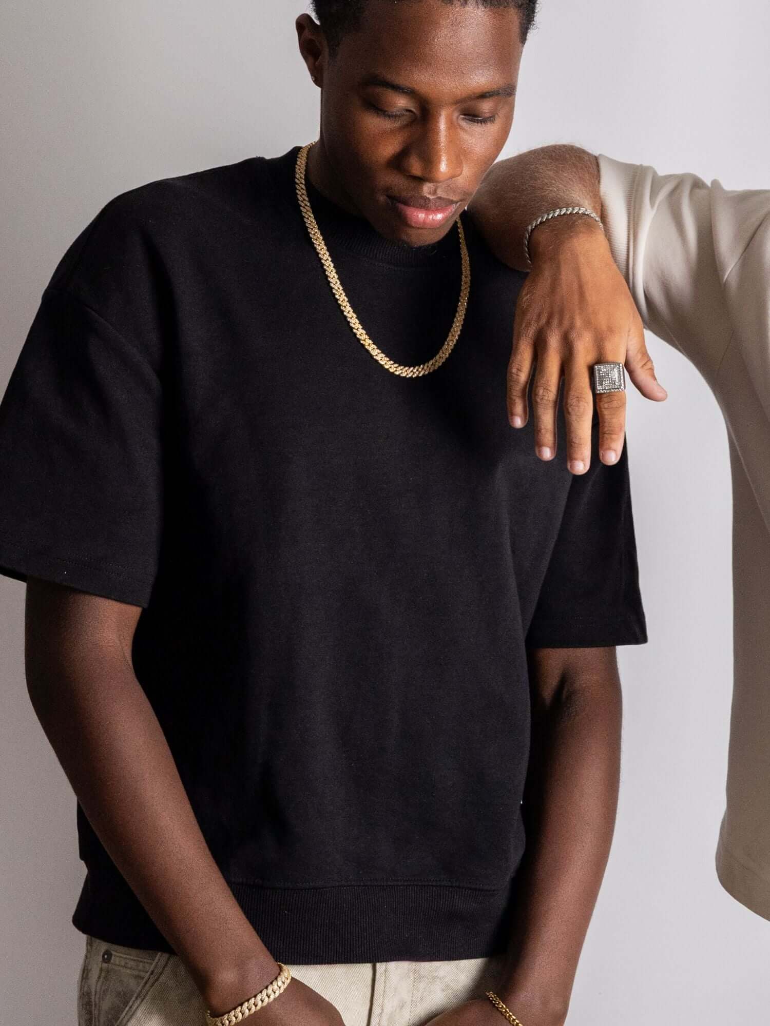 Man wearing a Cuban link ketting goud in ICED OUT style with a black shirt.