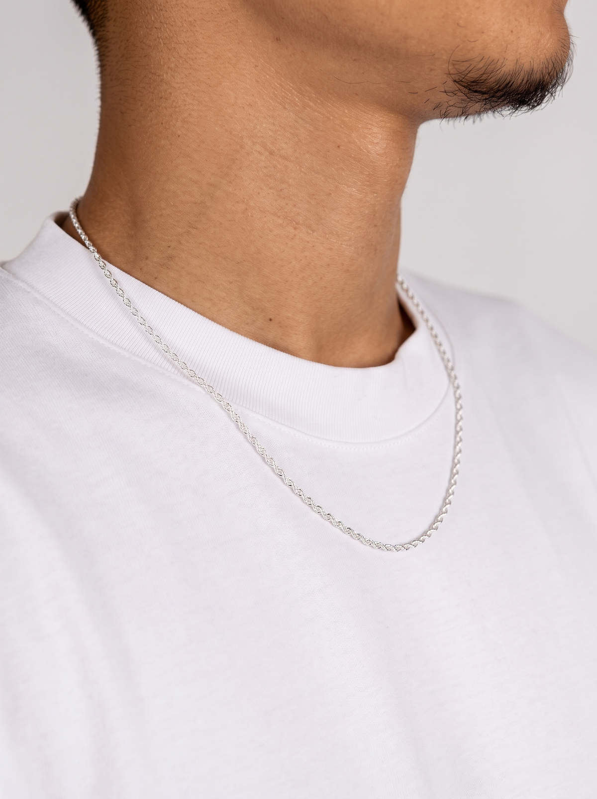 Rope Ketting 925 Sterling Zilver 2mm van opzij gedragen door een man in een wit T-shirt, fijne gedraaide rope schakels.
