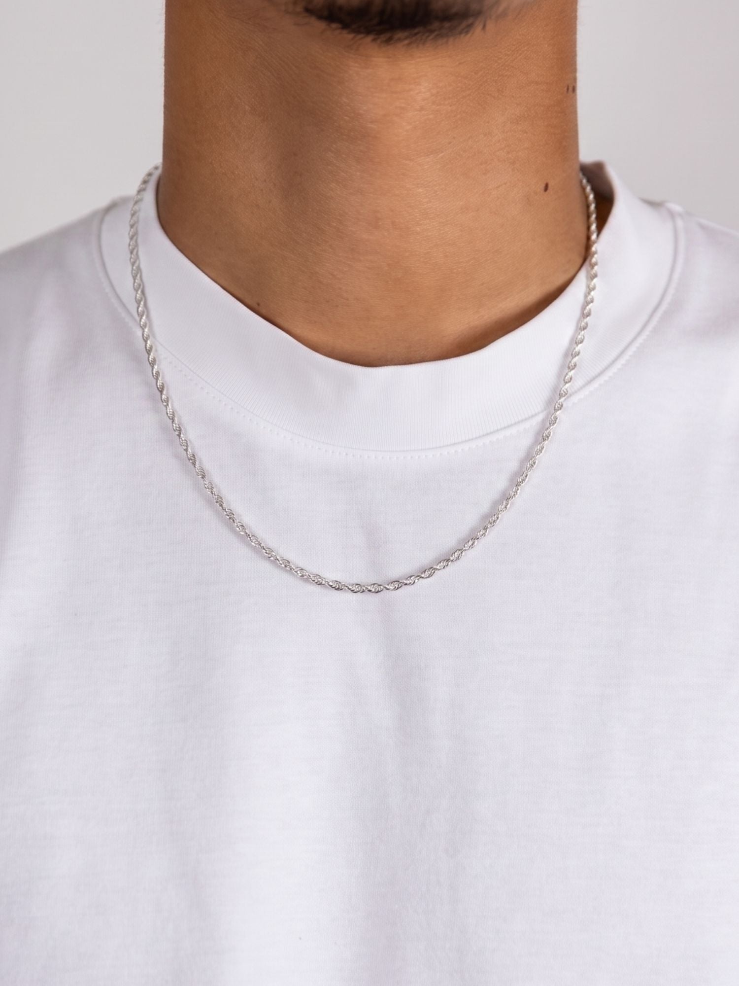 Rope Ketting 925 Sterling Zilver 2MM gedragen op een wit T-shirt, fijne gedraaide rope schakels met zilveren glans