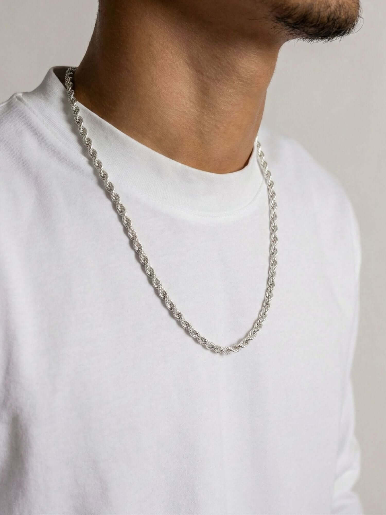 Collana Rope in argento sterling 925 4 mm indossata da un uomo in maglietta bianca, dettaglio di un look lussuoso e potente.