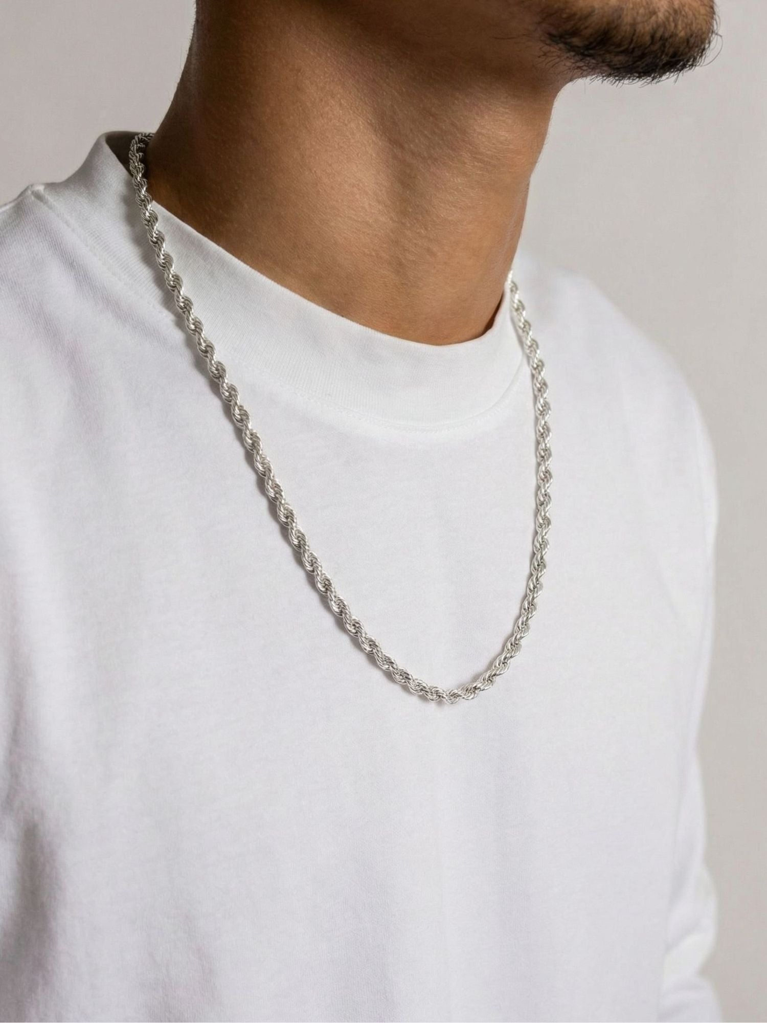 Chaîne corde en argent sterling 925 4 mm portée par un homme en t-shirt blanc, détail d’une allure luxueuse et puissante.