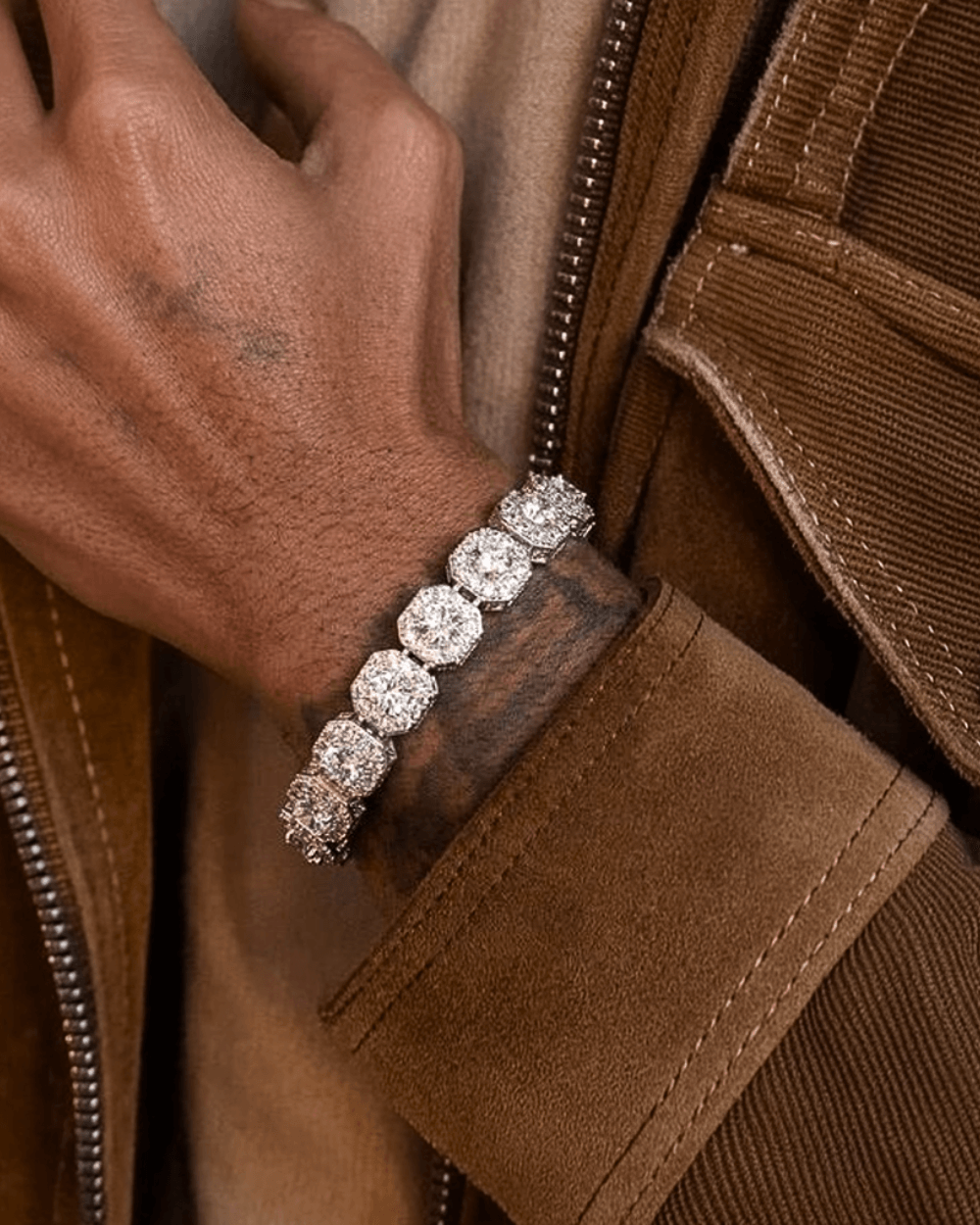 Clustered Zilveren Tennis Armband 10MM en 12MM gedragen om een pols met opvallende zilveren steentjes.