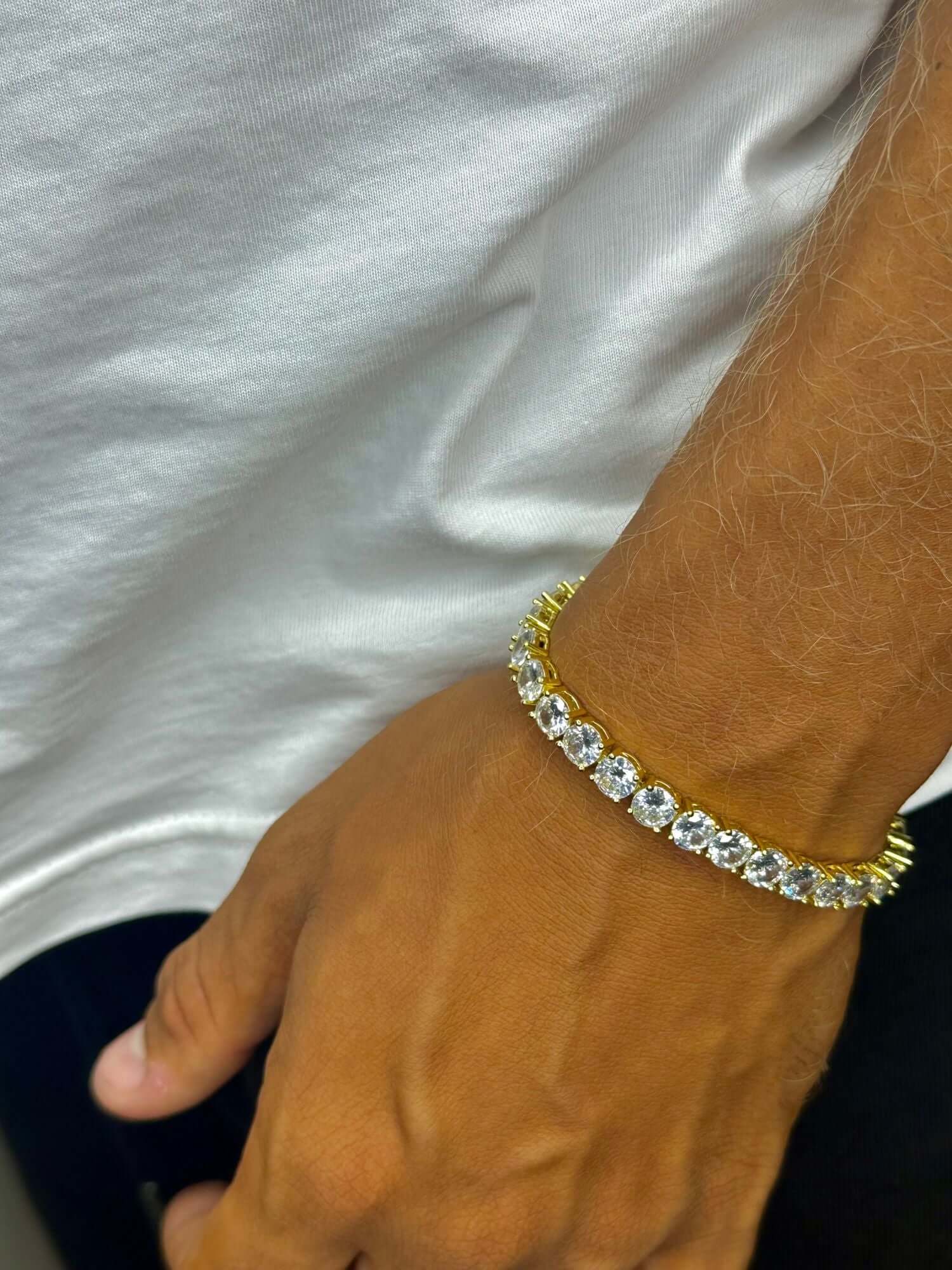 Gouden tennis armband met VVS CZ stenen, 3MM en 5MM, gedragen op een hand.