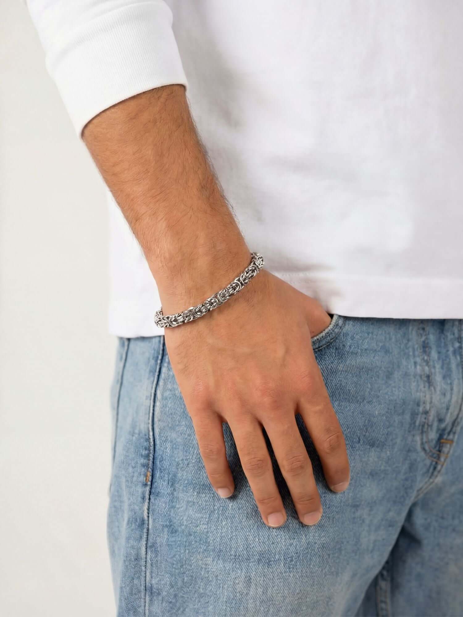 Zilveren Byzantijnse Konings Armband 6MM gedragen door een persoon in een casual outfit.