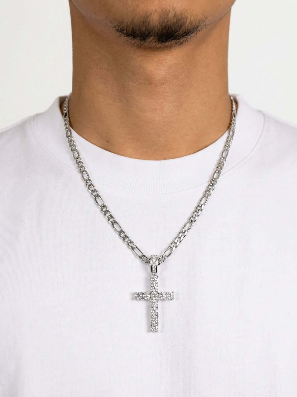 Ciondolo a croce in argento ICED OUT con finitura di lusso, visibile su una collana al collo.