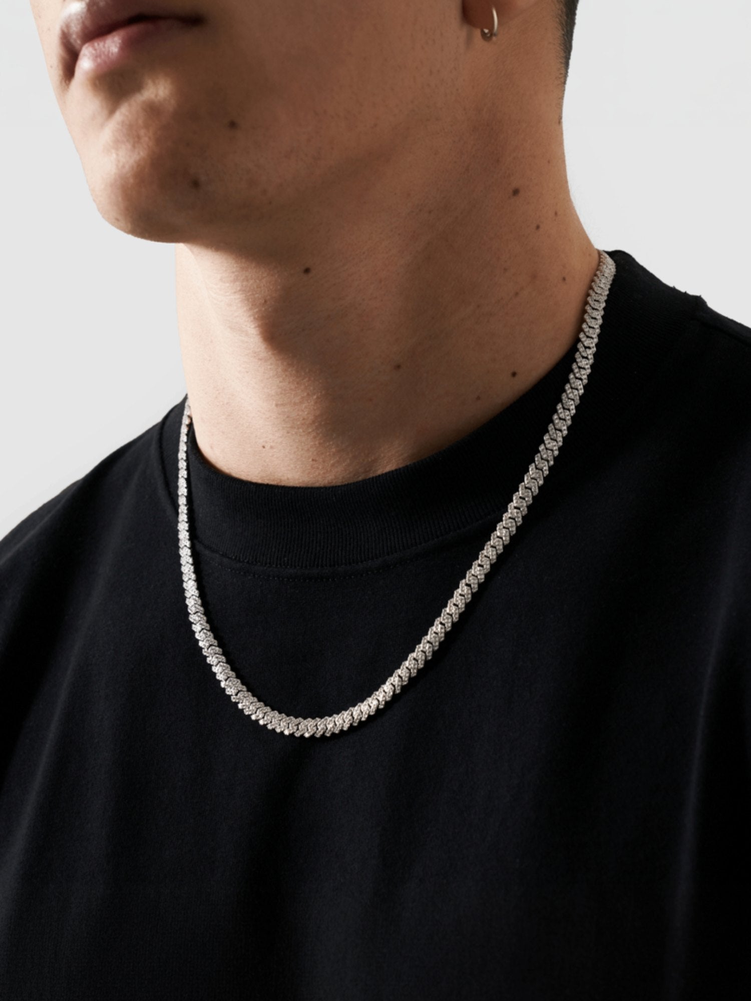 Een zilveren cuban link kettig op een man
