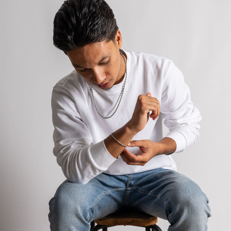Bestseller armband met kleurrijke stenen, gedragen bij een schitterend landschap met water op de achtergrond.