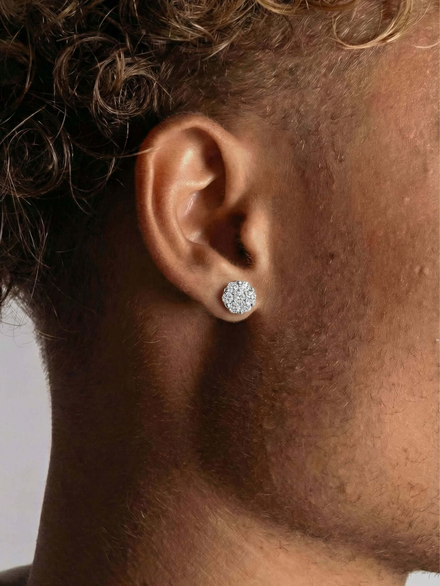 Orecchini pavé di diamanti in oro bianco 14K indossati da un modello con capelli ricci