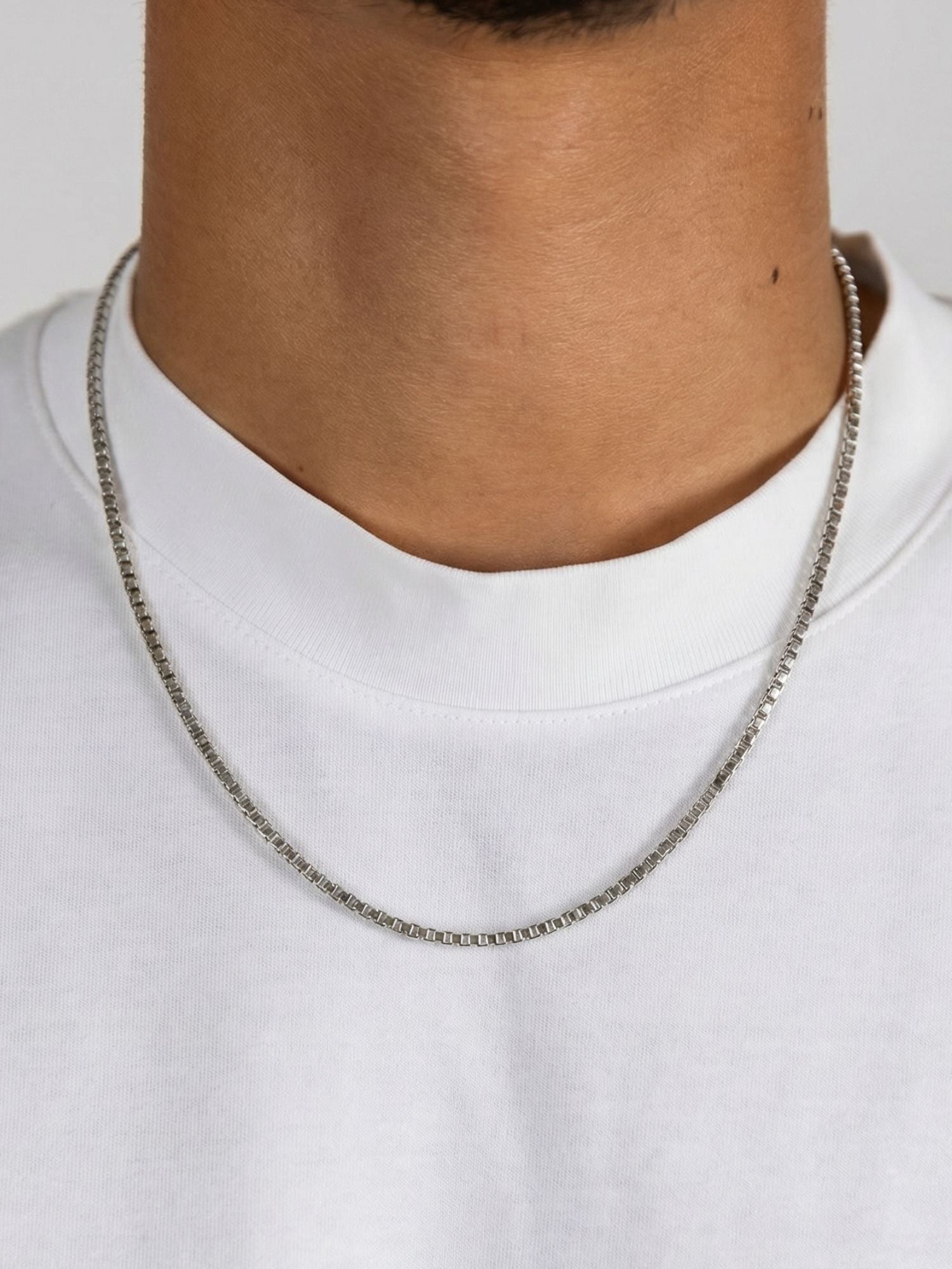 Zilveren box ketting 2MM en 3MM gedragen door man in witte T-shirt