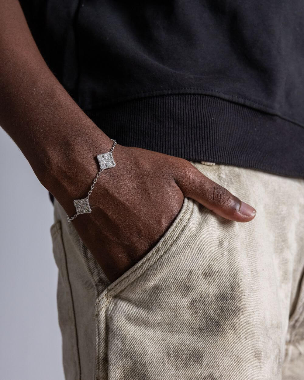 Man wearing Clover armband zilver ICED OUT jewelry, showcasing its unique design and sparkle.