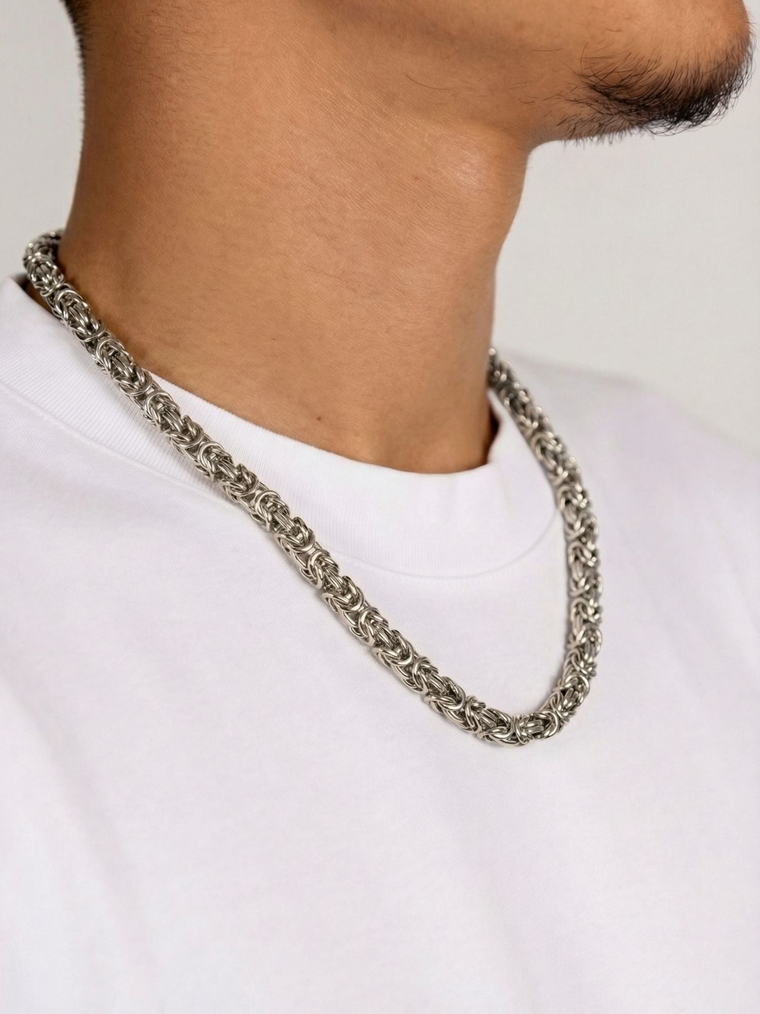 Zilveren Byzantijnse Konings Ketting 6MM gedragen door een man op een witte shirt.