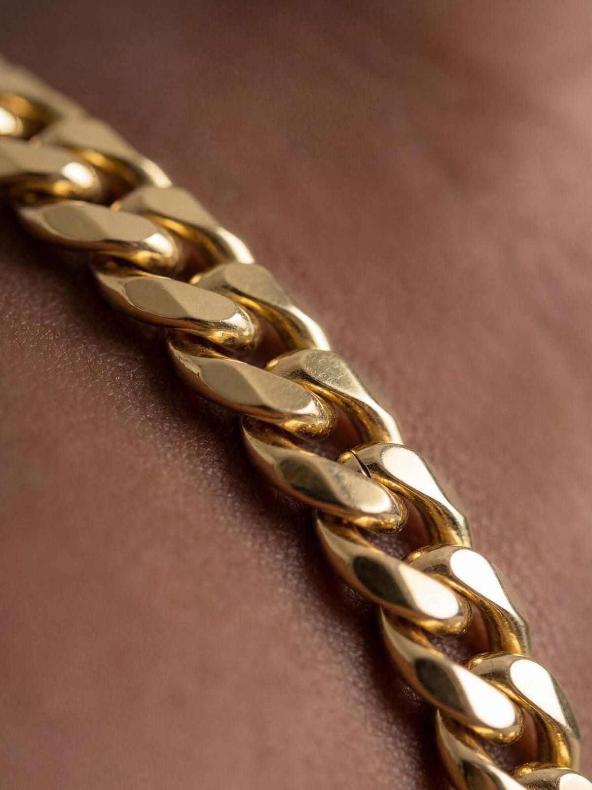 Bracciale cubano placcato in oro 18K (5 mm) primo piano di bracciale a maglia cubana da 5 mm con lucida placcatura in oro 18K al polso