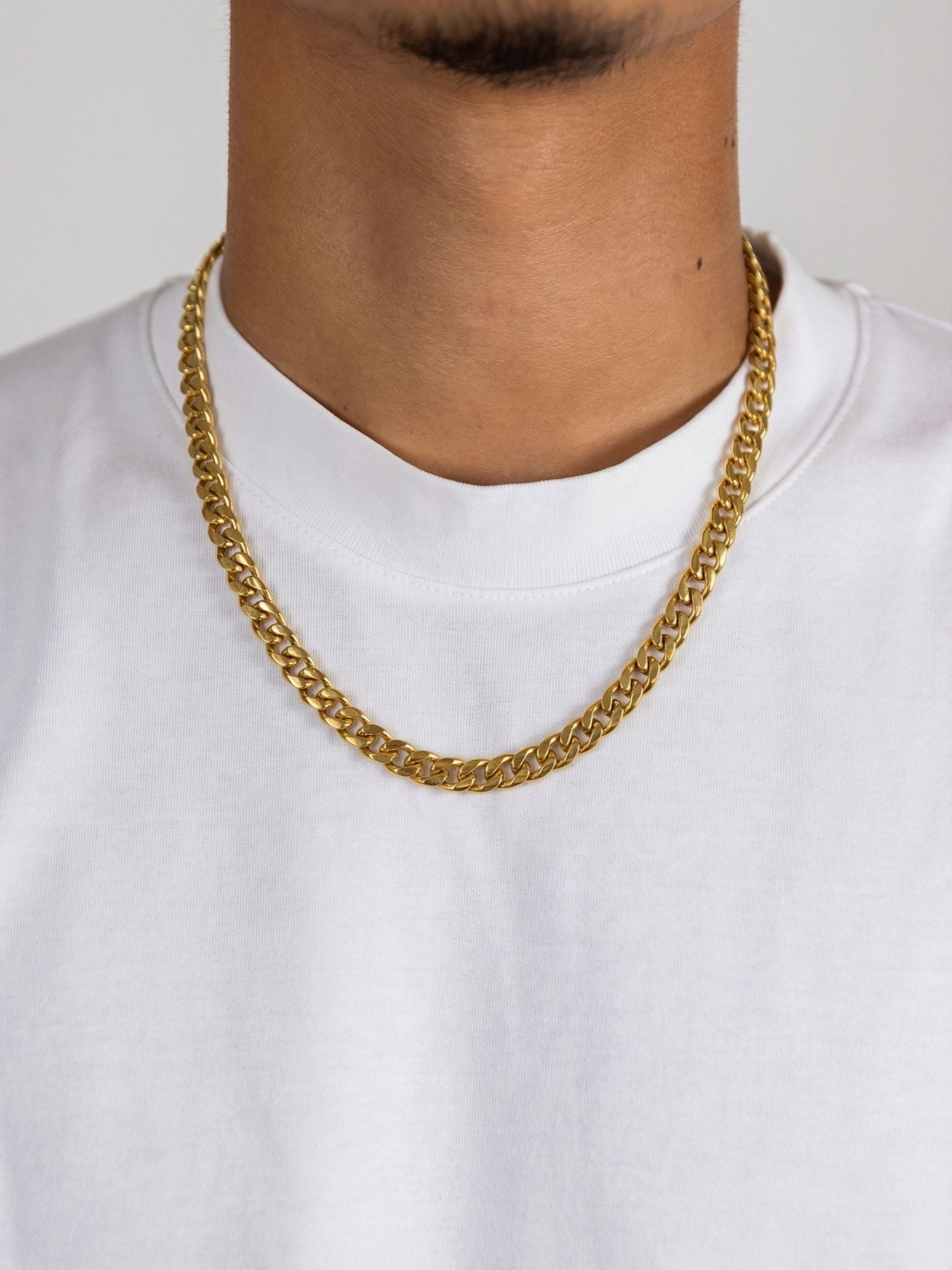 Gouden Cuban ketting 3MM-8MM gedragen door een man in een witte t-shirt, stijlvolle en luxe uitstraling.