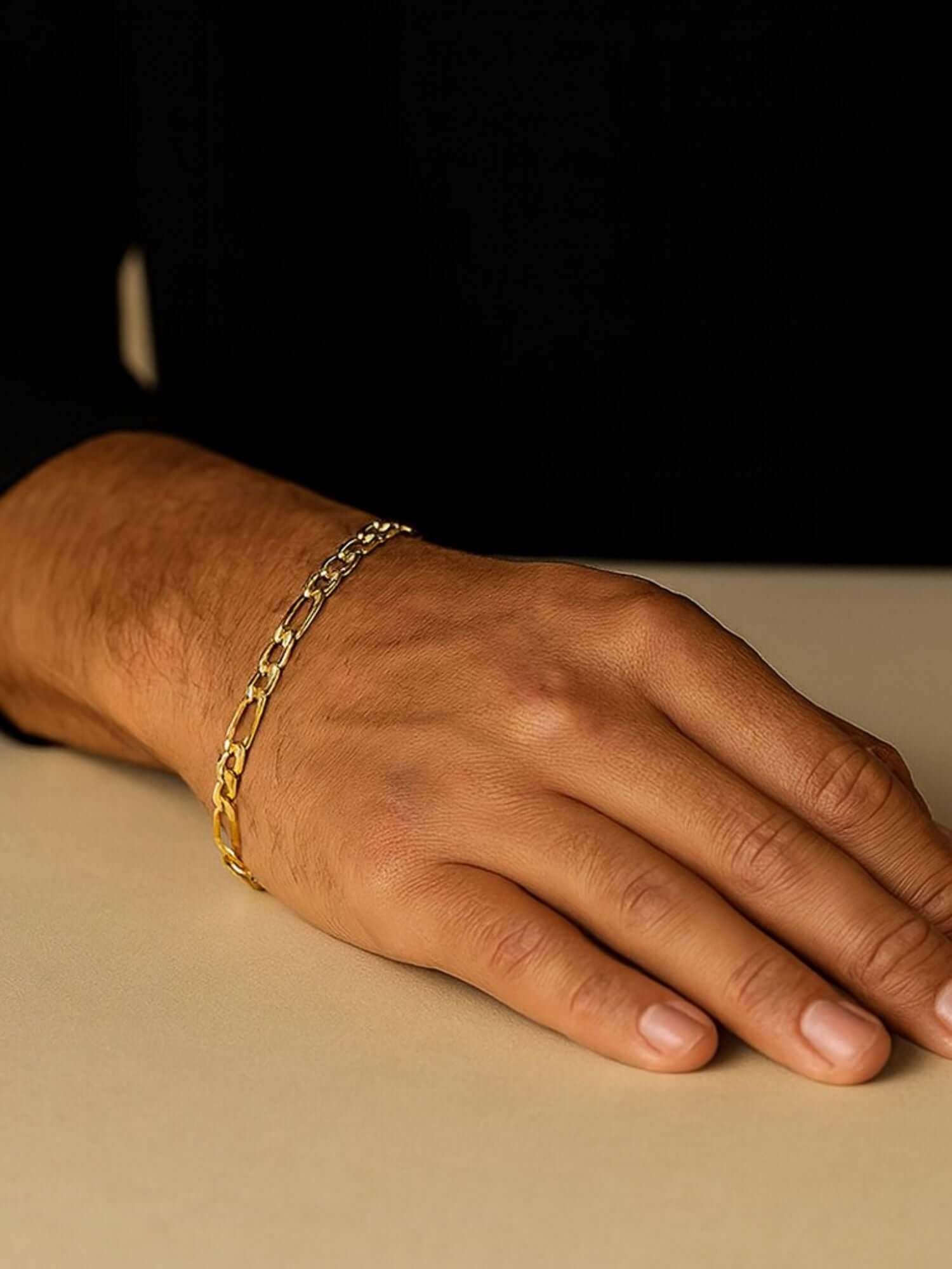 Gouden Figaro armband 3MM en 5MM op een hand, perfect voor elegante styling en moderne kwaliteit.