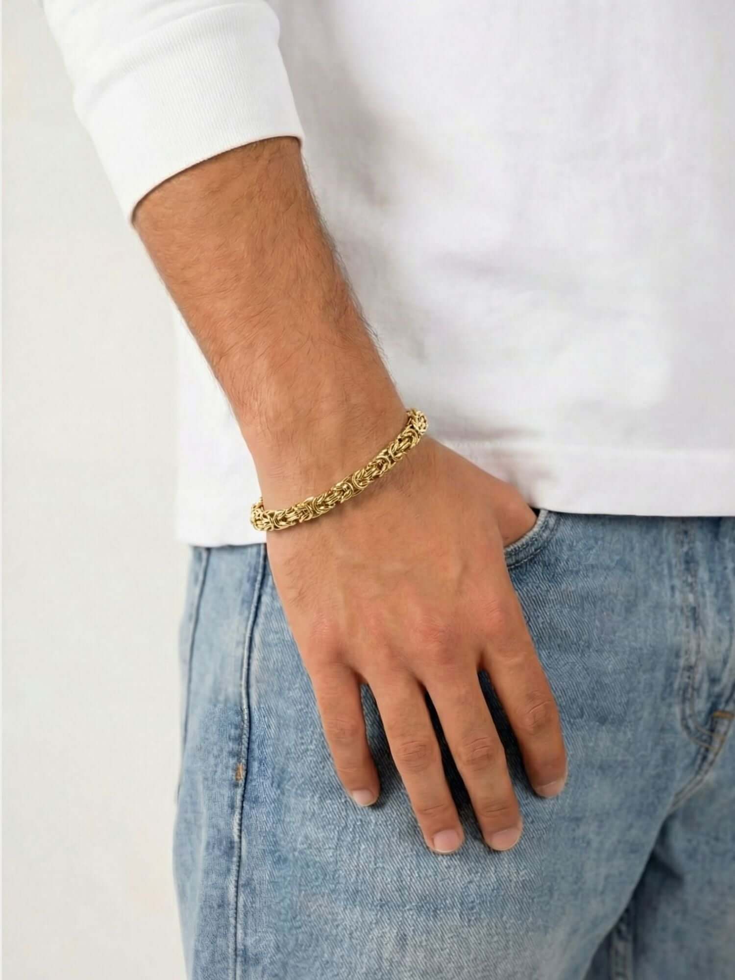 Gold Byzantine King Bracelet 6MM worn by a man with light denim jeans and a white shirt.