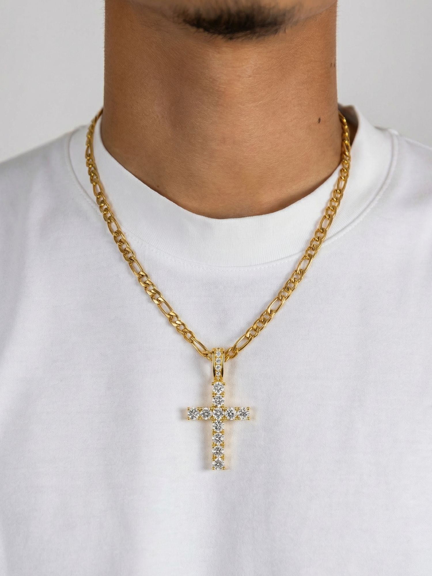 Gouden Kruis Hanger ICED OUT gedragen door man met gouden ketting op witte T-shirt.