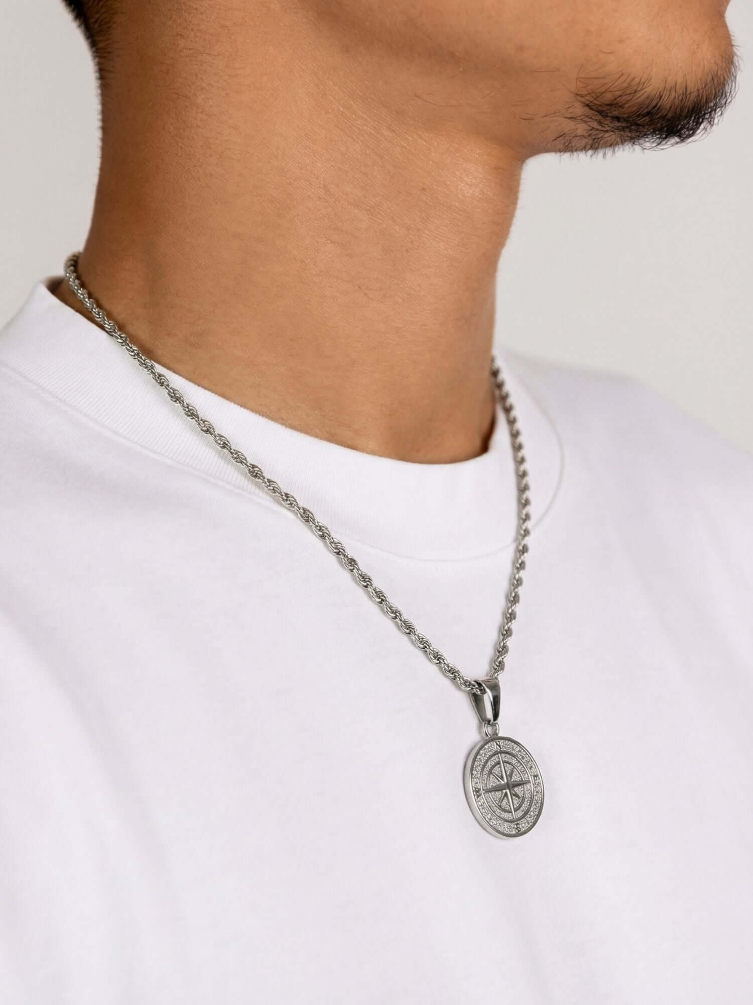 Kompas Hanger Zilver gedragen door man met zilveren ketting, symboliseert richting en avontuur.