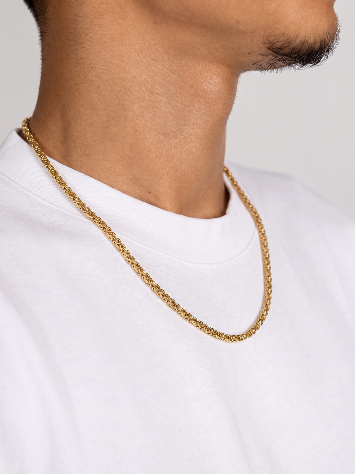 King's Chain Gold Stainless Steel (4mm) worn by a model in a white T-shirt, side view