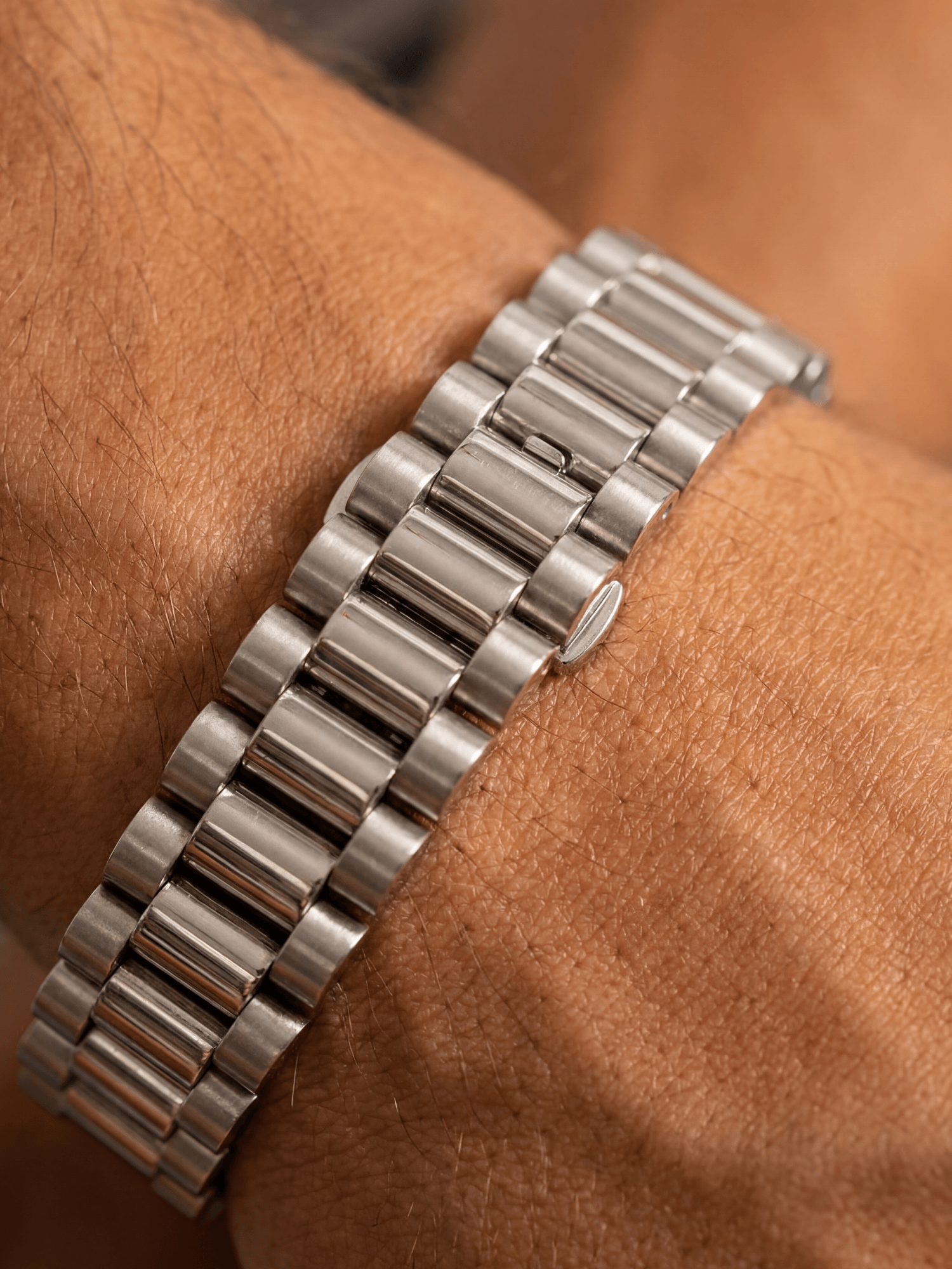 Rolex Armband Zilver RVS (10mm) op een pols, met iconisch schakeldesign en luxe uitstraling.
