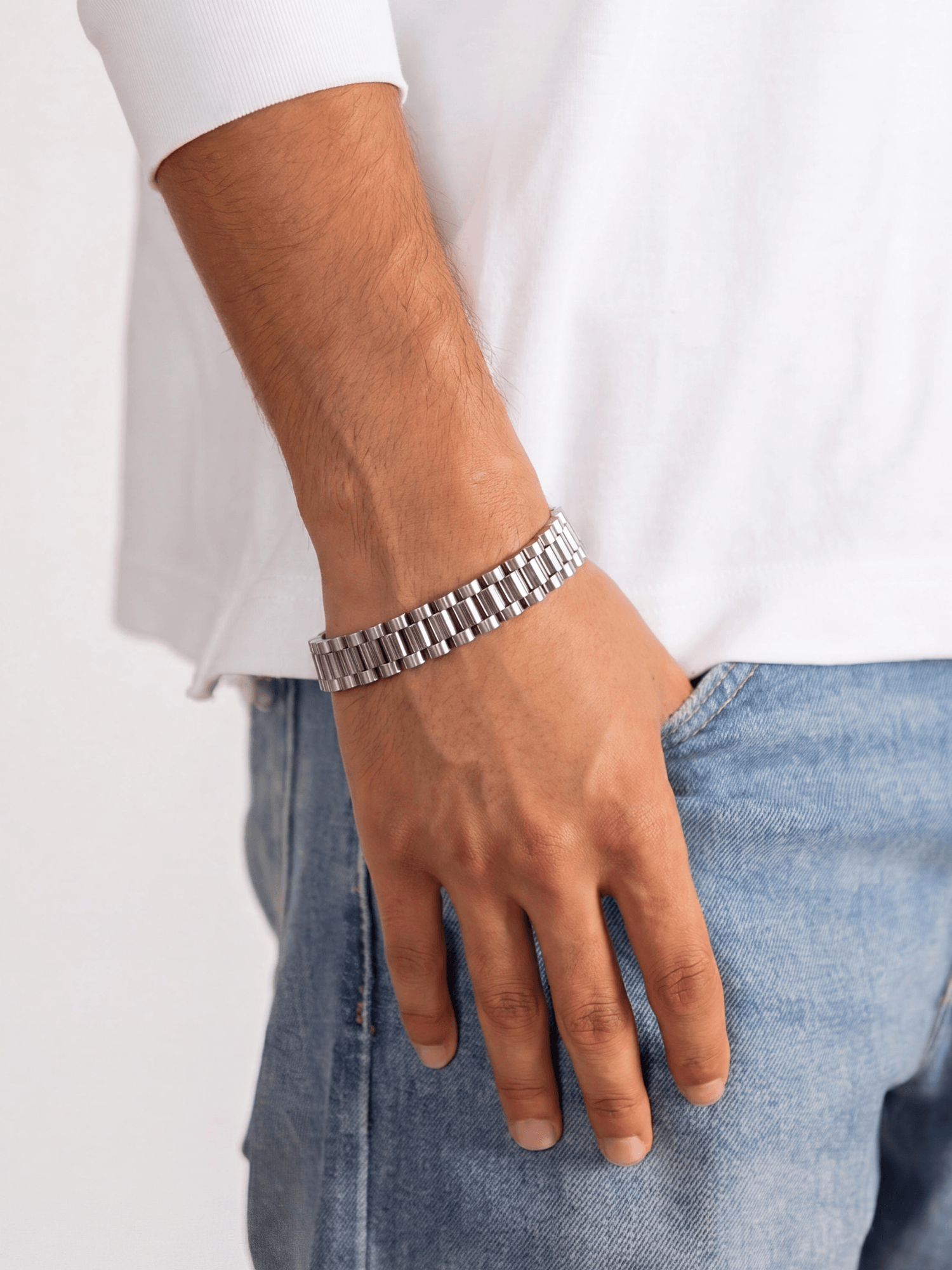 Man draagt een Rolex Armband Zilver RVS (10mm) met luxe schakelontwerp, stijlvol afgebeeld.