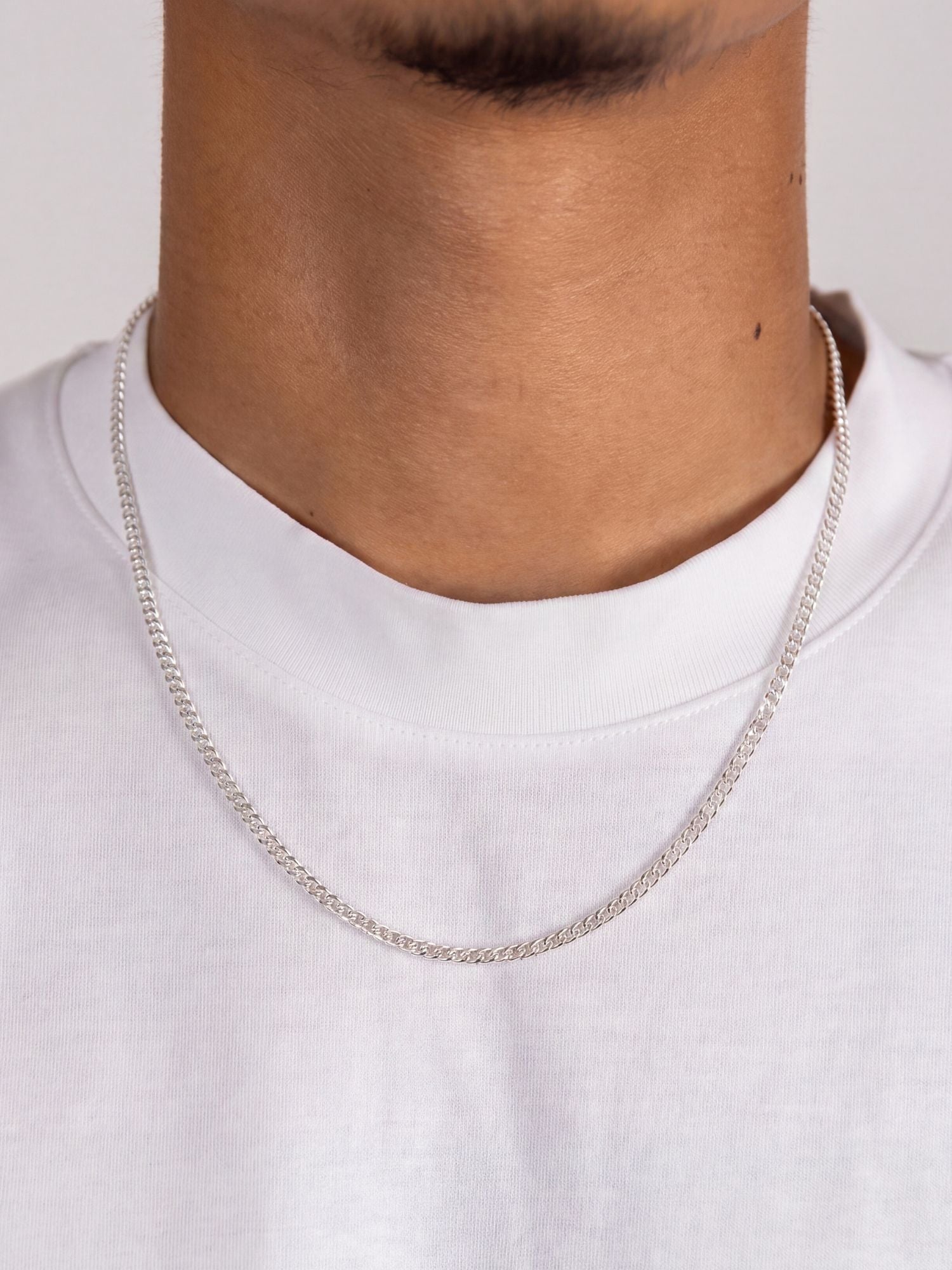 Cuban Ketting 925 Sterling Zilver 2MM gedragen door een man in wit T-shirt, elegante uitstraling.