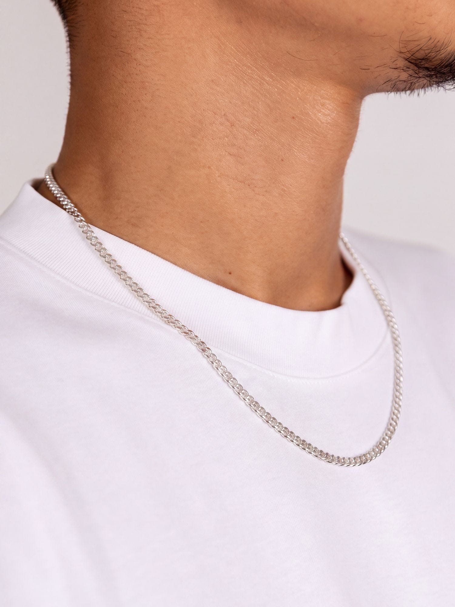 Cuban Ketting 925 Sterling Zilver 2MM gedragen door een man in een wit T-shirt.