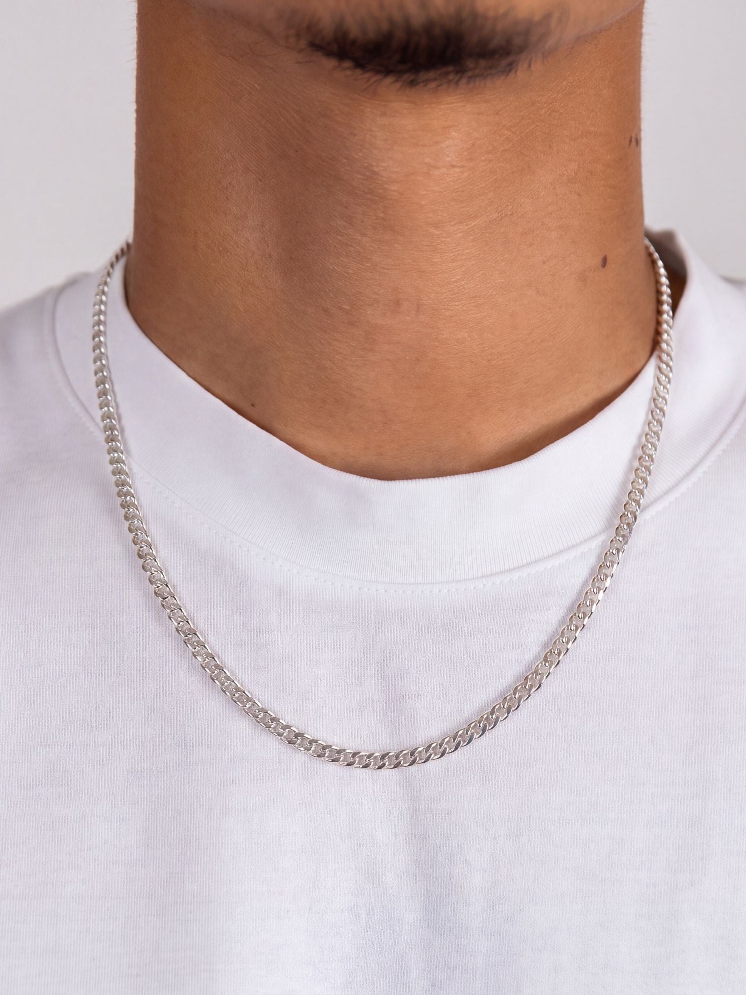 Cuban Ketting 925 Sterling Zilver 4MM gedragen door model met witte T-shirt en sterke uitstraling.