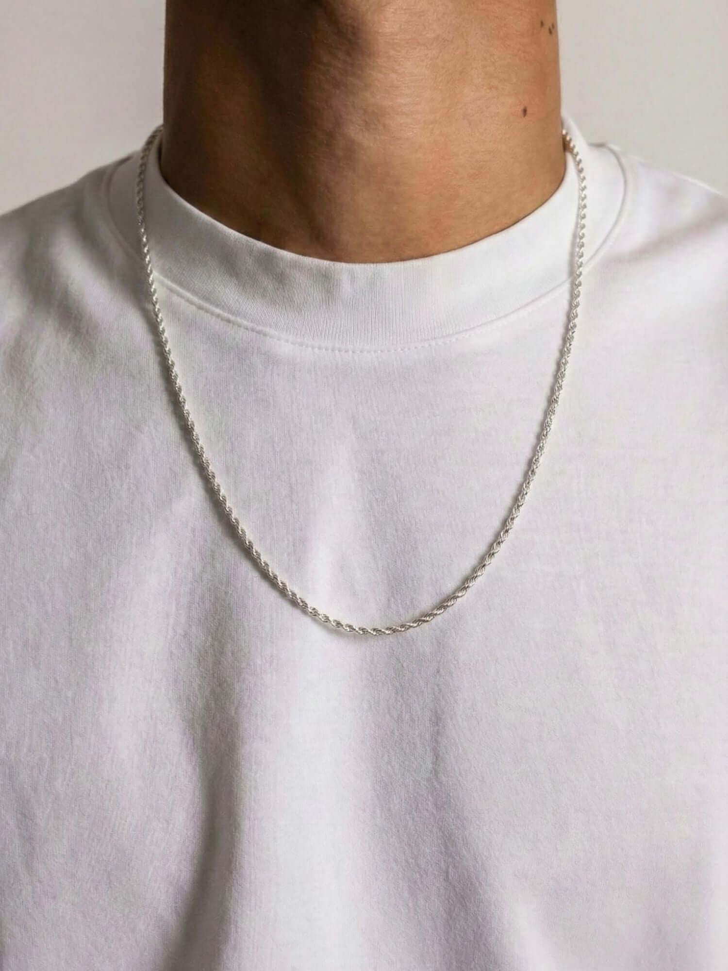 Collana Rope in argento sterling 925 3MM indossata da un uomo con un maglione bianco, design lussuoso e senza tempo.