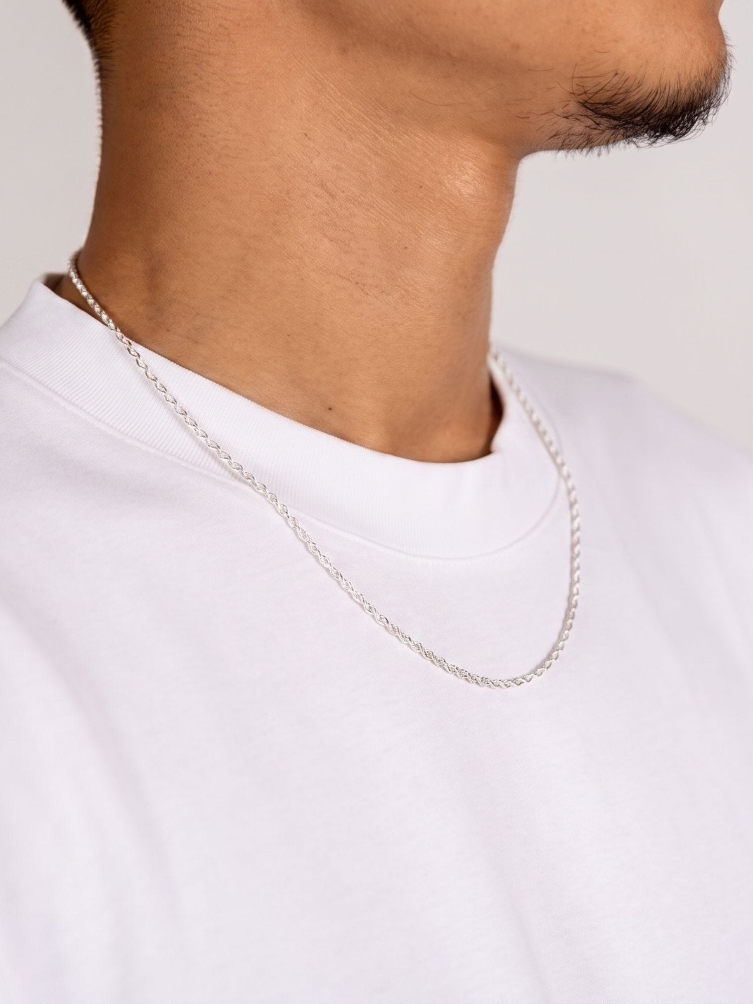 Rope Ketting 925 Sterling Zilver 2MM van opzij gedragen door een man in wit T-shirt, detail van de fijne gedraaide schakels